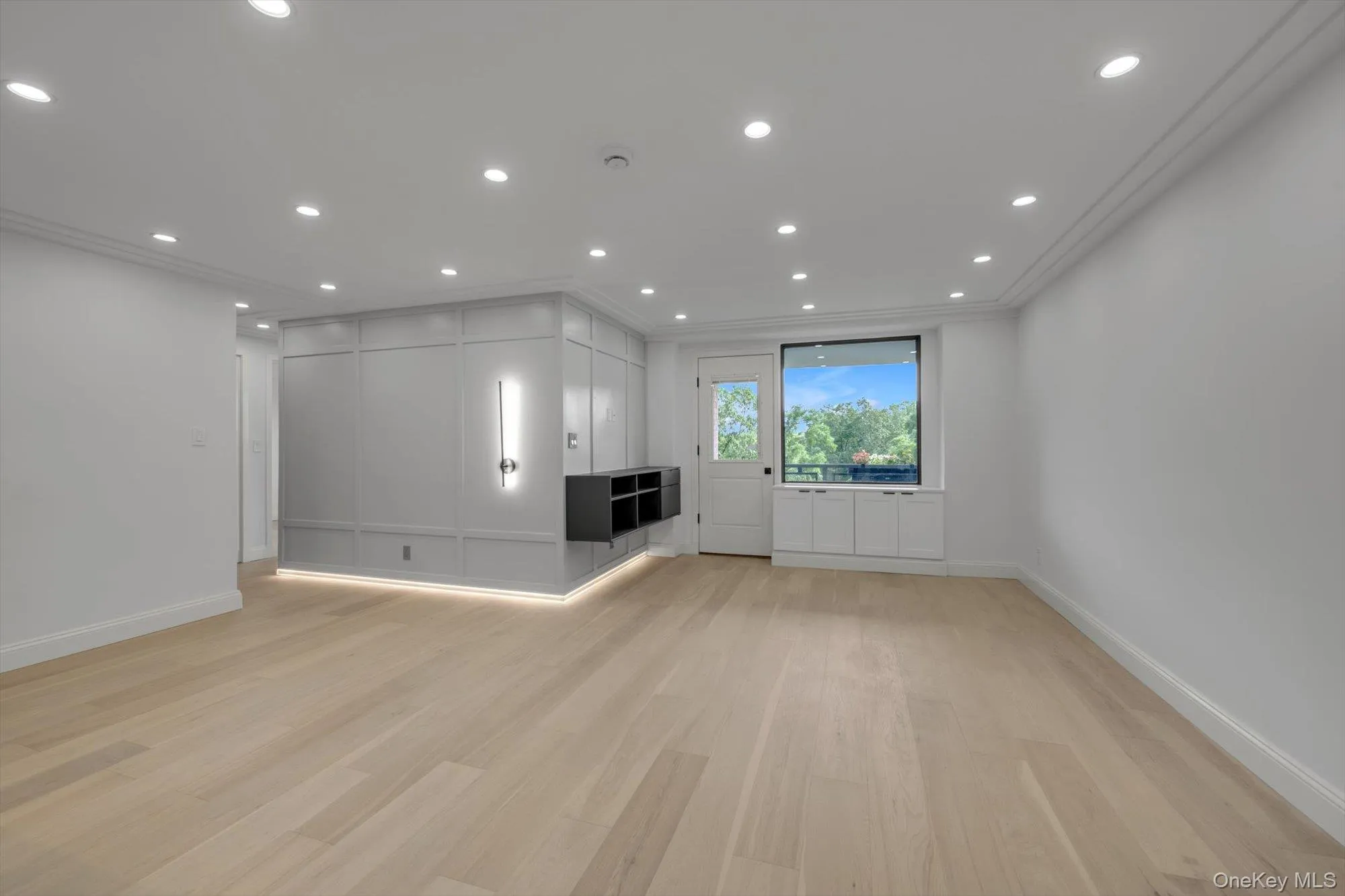 Unfurnished living room with light wood-type flooring, recessed lighting, and ornamental molding Unfurnished living room with light wood-type flooring, recessed lighting, and ornamental molding