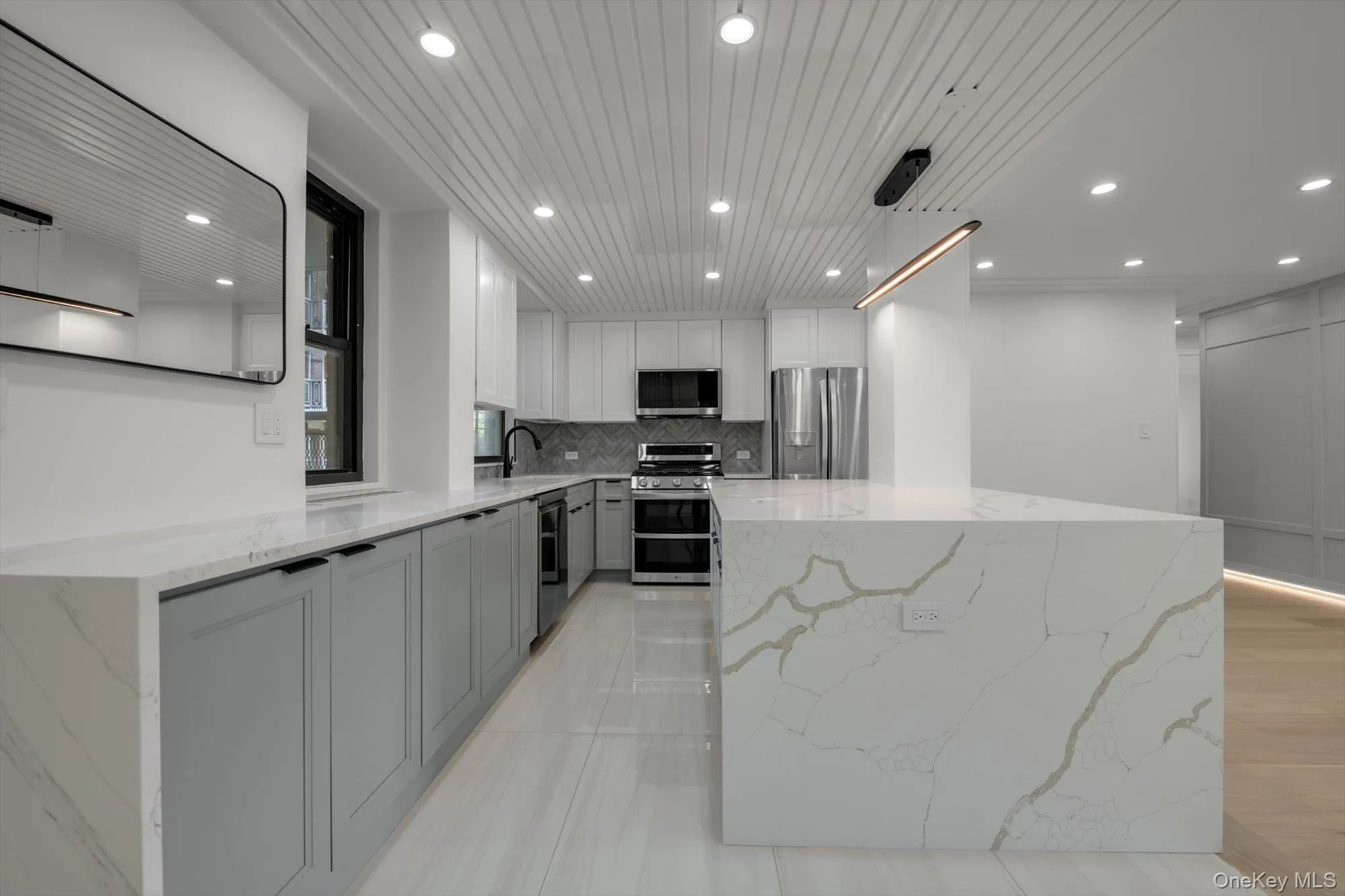 Kitchen featuring appliances with stainless steel finishes, recessed lighting, tasteful backsplash, a center island, and light stone countertops Kitchen featuring appliances with stainless steel finishes, recessed lighting, tasteful backsplash, a center island, and light stone countertops