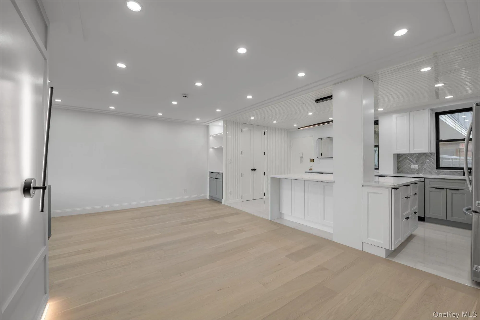 Kitchen featuring light wood-type flooring, open floor plan, decorative backsplash, recessed lighting, and white cabinets Kitchen featuring light wood-type flooring, open floor plan, decorative backsplash, recessed lighting, and white cabinets