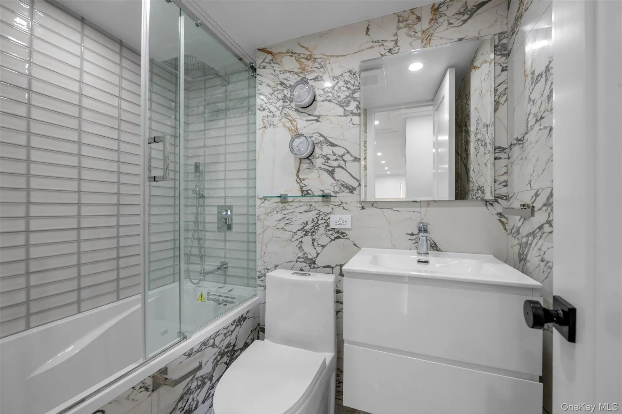 Bathroom featuring tile walls, tiled shower / bath, vanity, and recessed lighting Bathroom featuring tile walls, tiled shower / bath, vanity, and recessed lighting