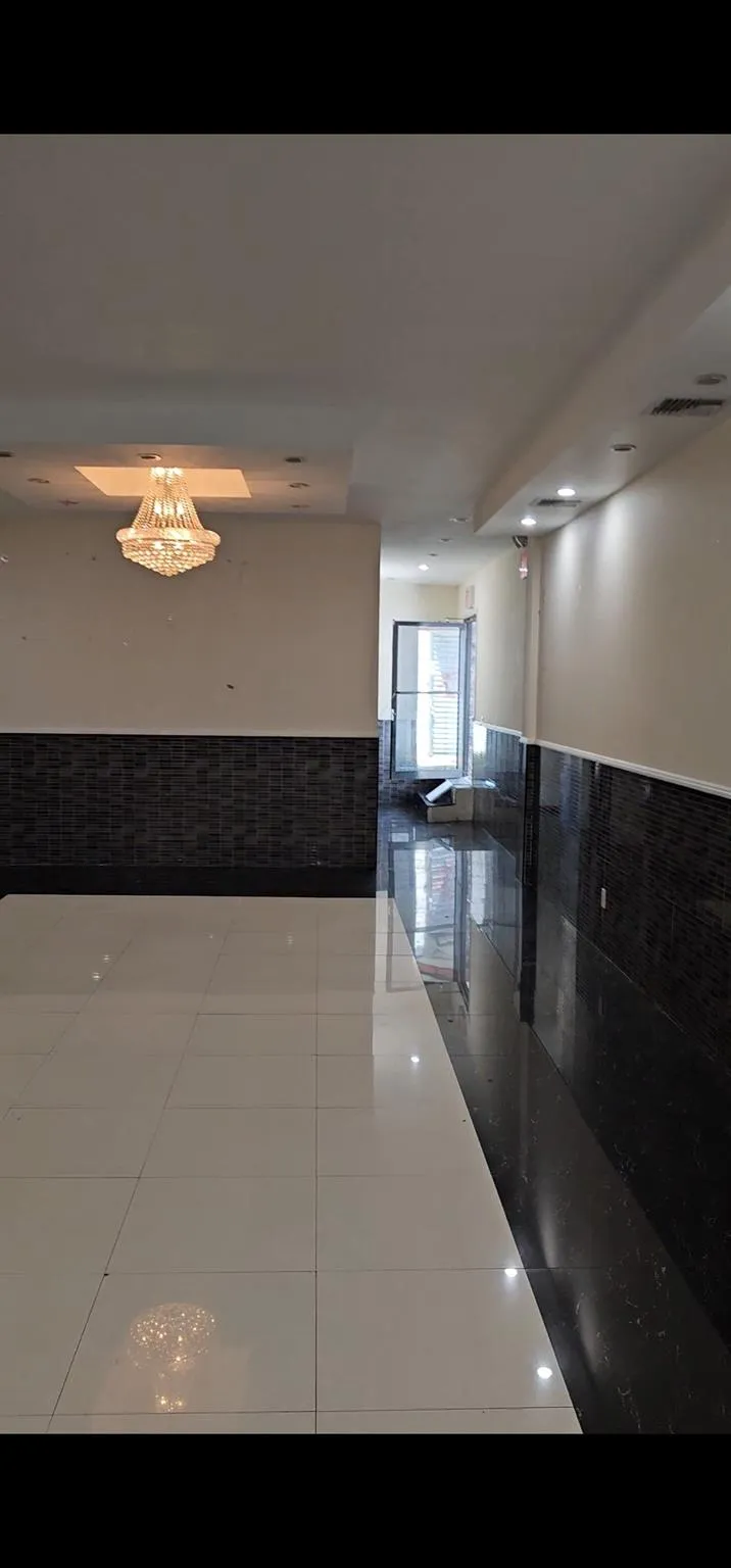 Corridor with wainscoting, tile patterned floors, and tile walls Corridor with wainscoting, tile patterned floors, and tile walls