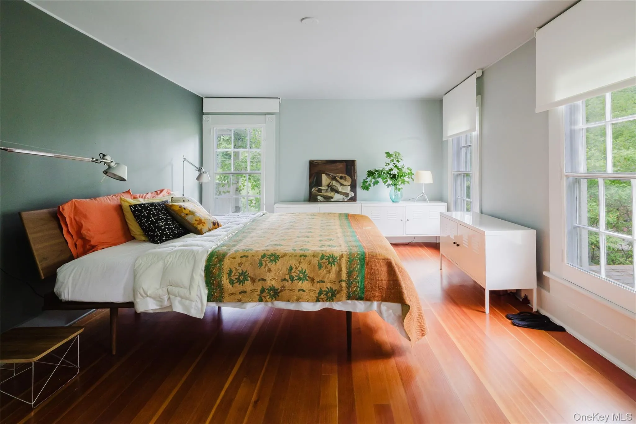 Bedroom featuring light wood-type flooring and multiple windows Bedroom featuring light wood-type flooring and multiple windows