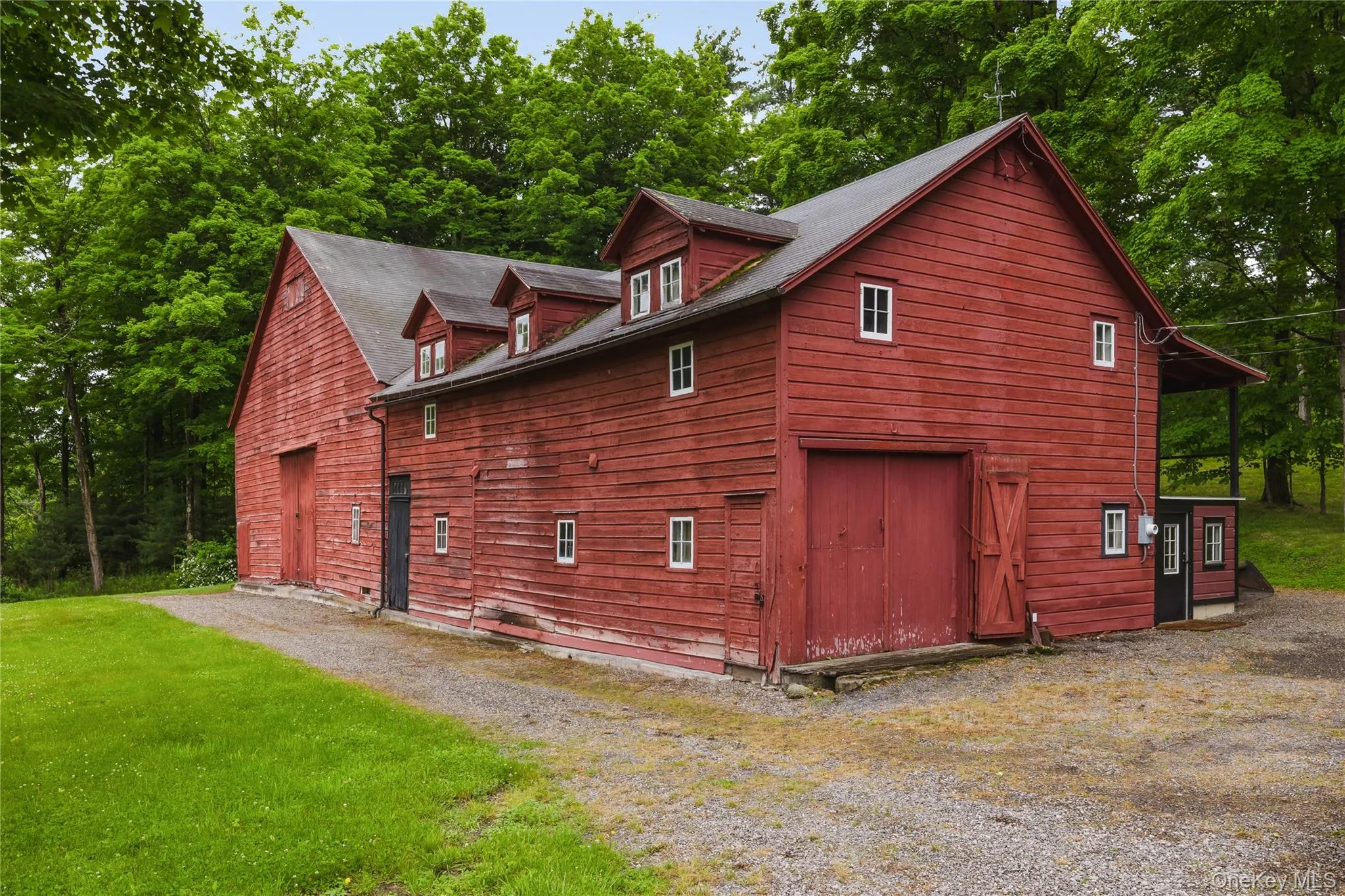 View of side of property featuring a yard, a barn, and view of scattered trees View of side of property featuring a yard, a barn, and view of scattered trees