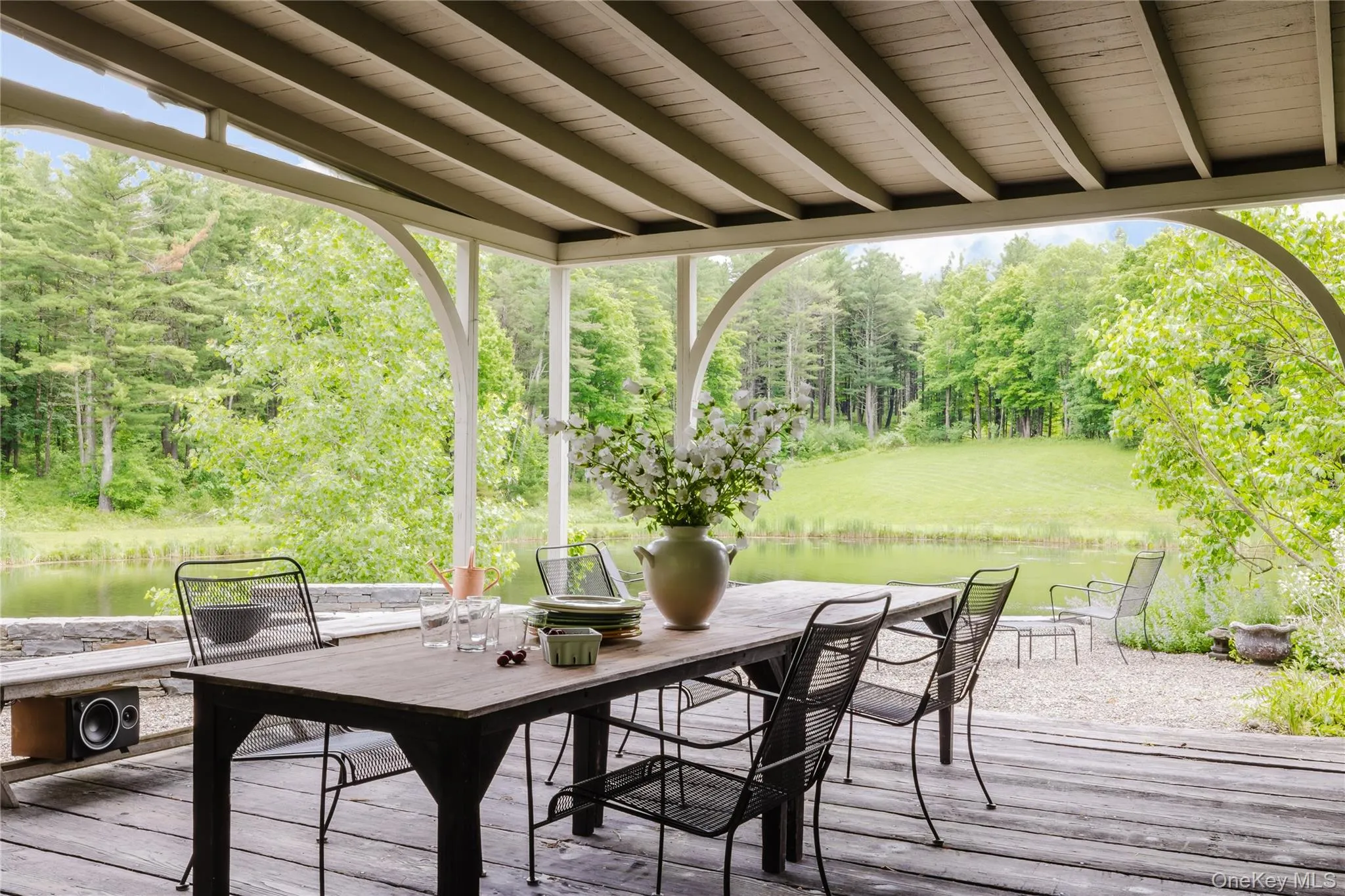 Wooden terrace featuring outdoor dining area and a water view Wooden terrace featuring outdoor dining area and a water view