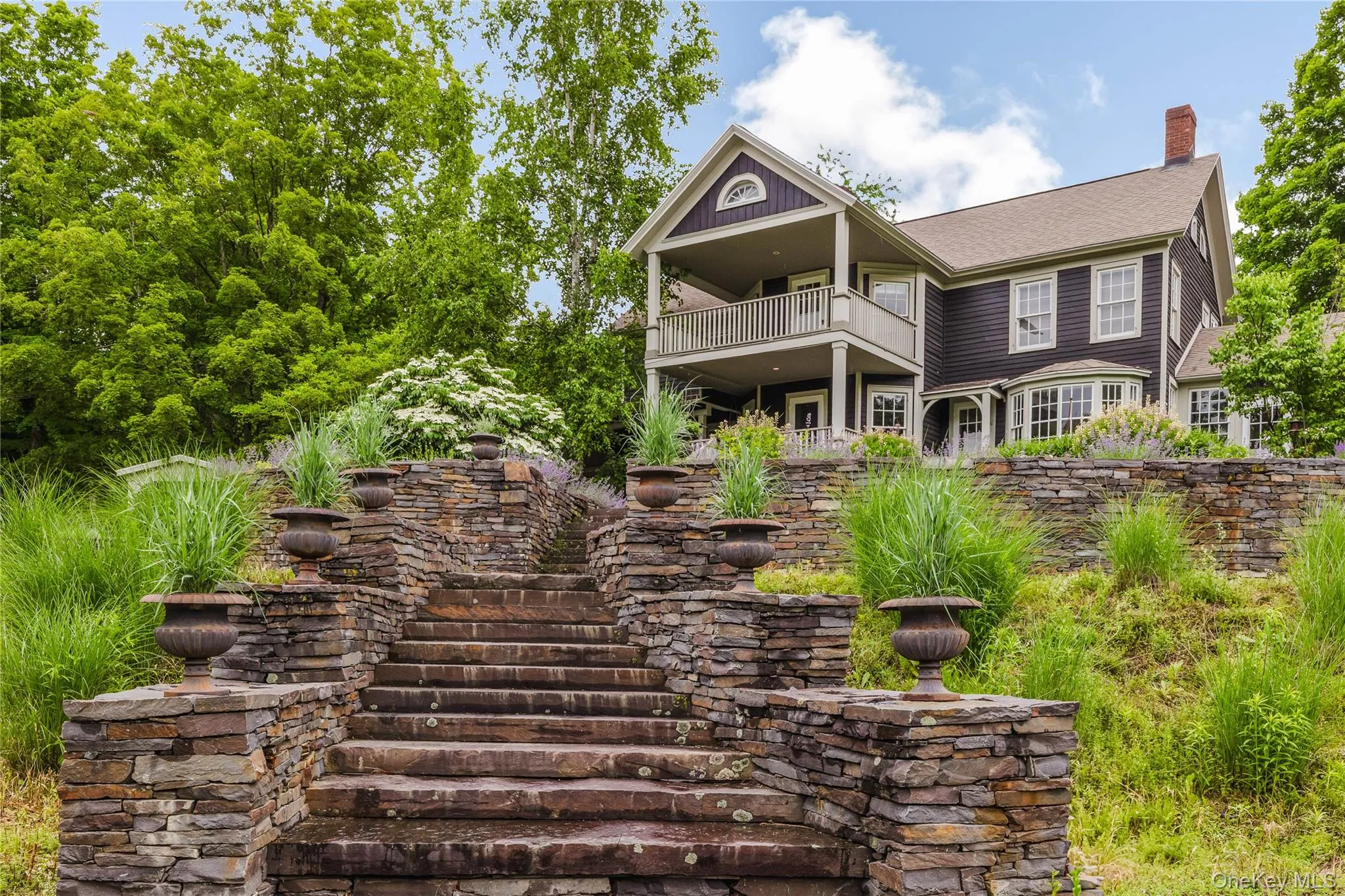 View of front of property with a balcony, a chimney, and roof with shingles View of front of property with a balcony, a chimney, and roof with shingles