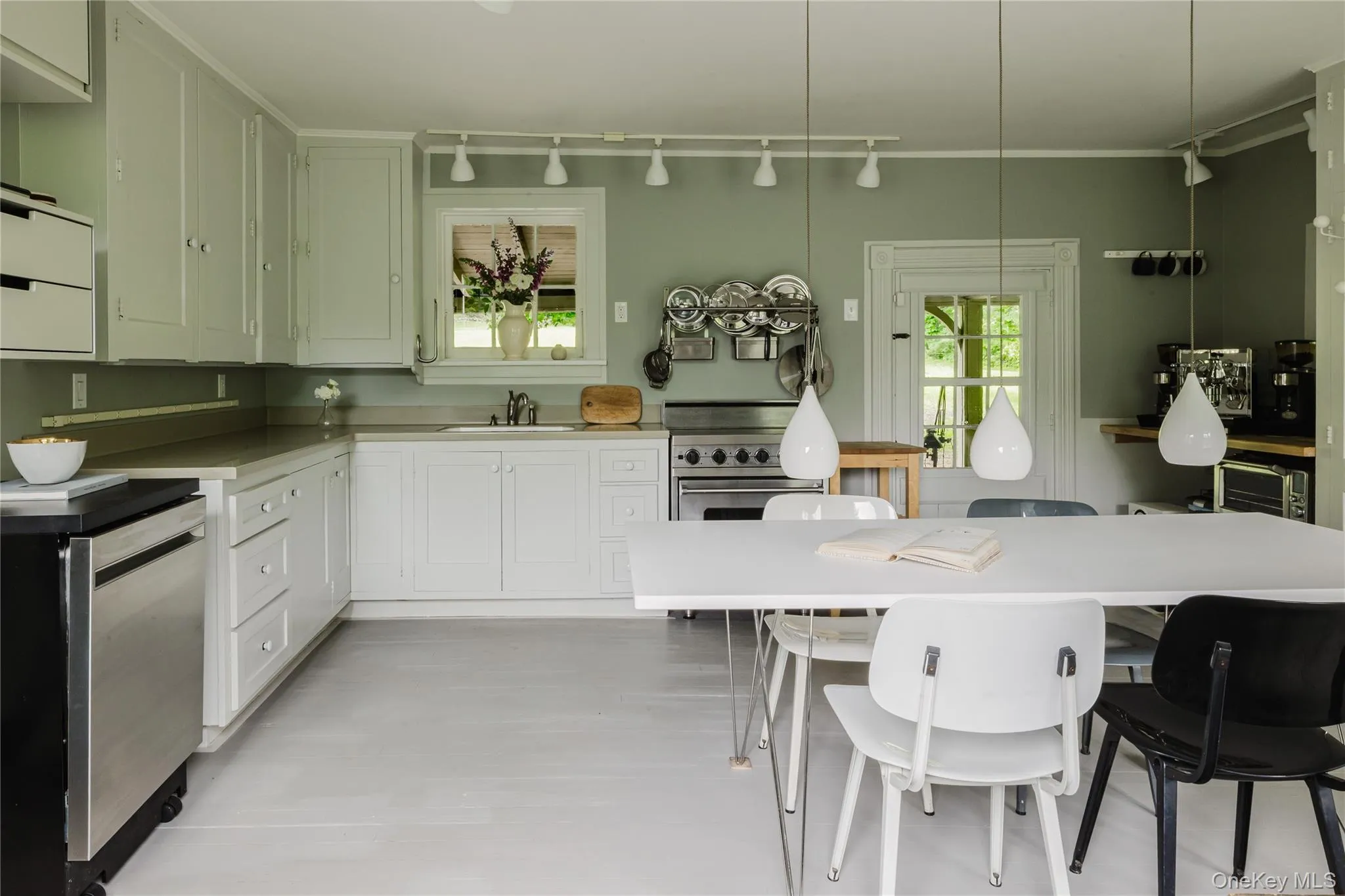 Kitchen with appliances with stainless steel finishes, track lighting, light countertops, and a breakfast bar Kitchen with appliances with stainless steel finishes, track lighting, light countertops, and a breakfast bar