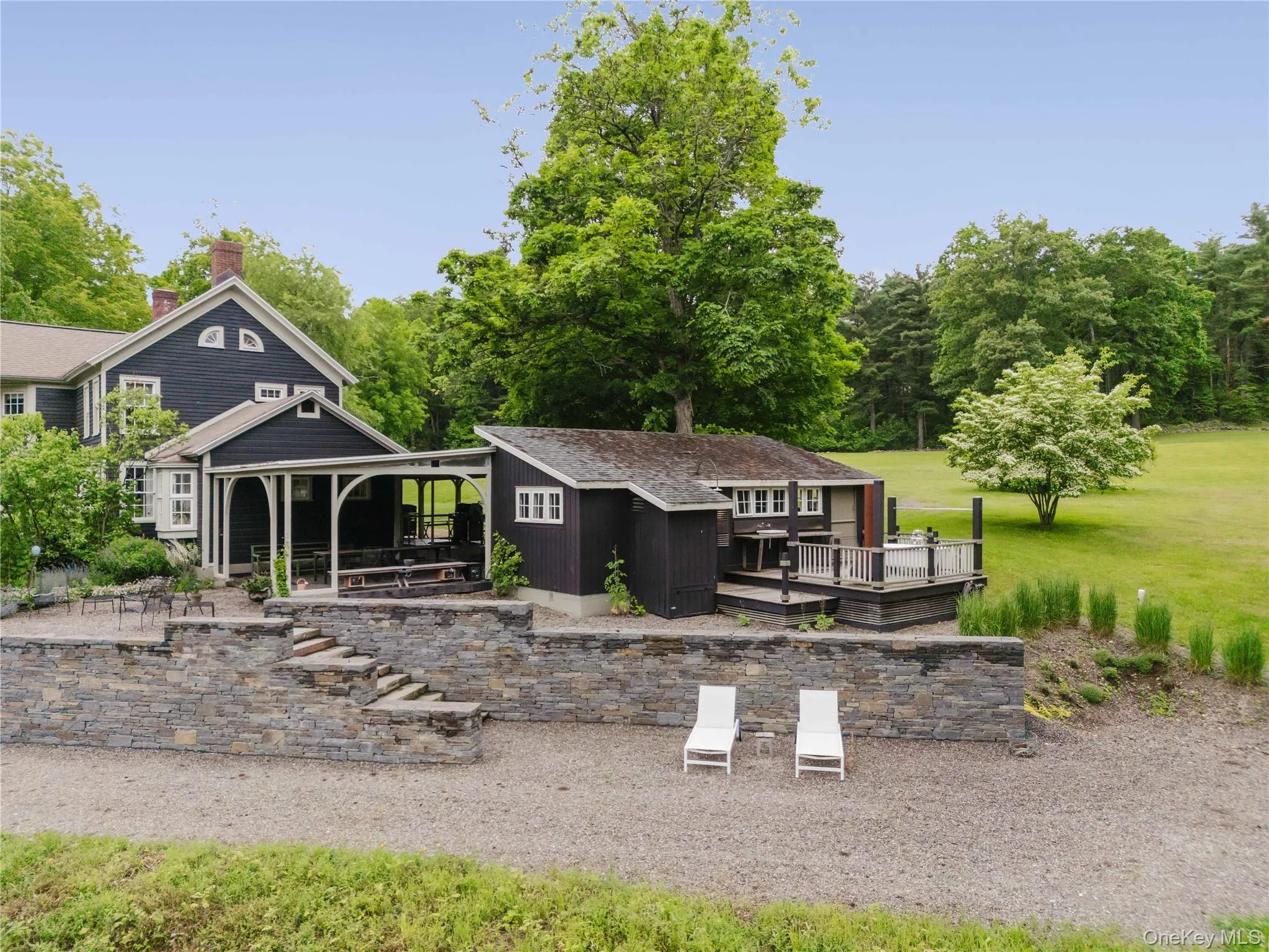 Back of house featuring a deck, a storage unit, and a chimney Back of house featuring a deck, a storage unit, and a chimney