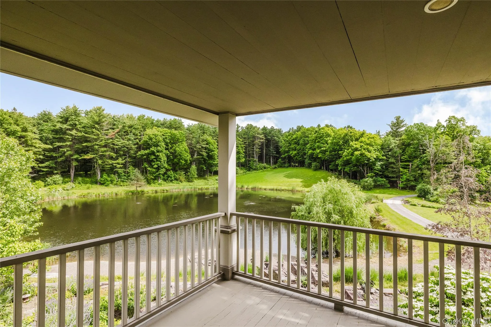 Deck featuring a water view and view of wooded area Deck featuring a water view and view of wooded area