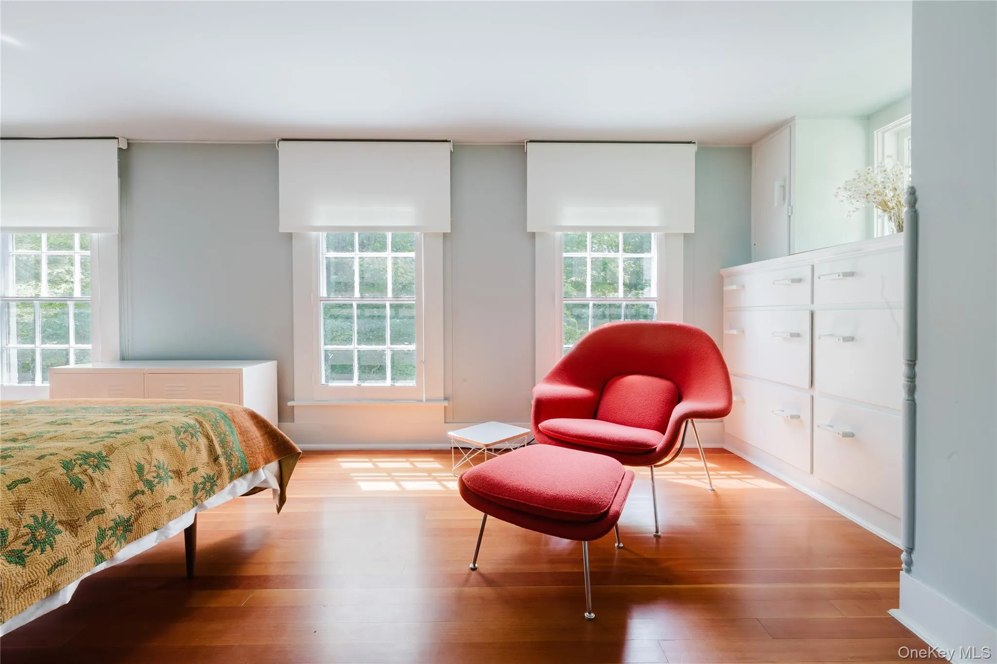 Bedroom featuring wood finished floors and multiple windows Bedroom featuring wood finished floors and multiple windows