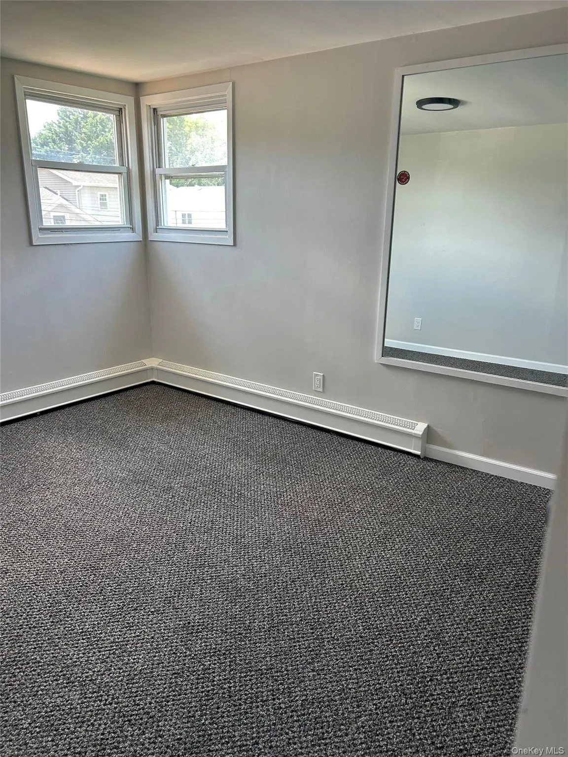 Spare room with baseboards and carpet flooring Spare room with baseboards and carpet flooring