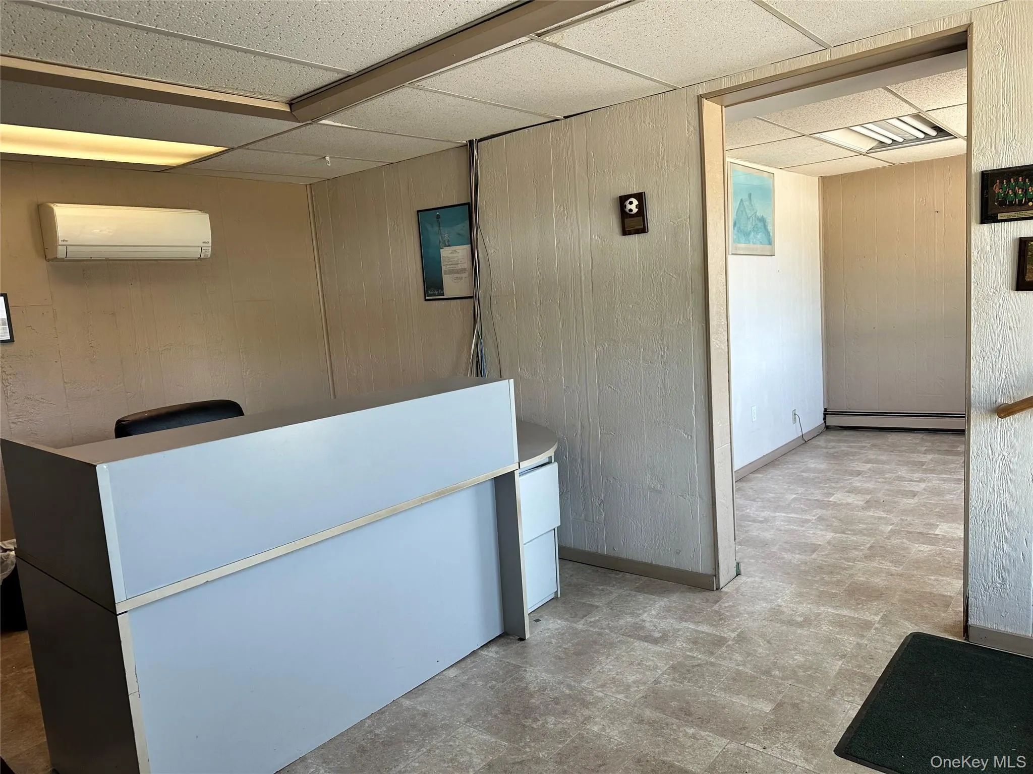 Reception area featuring wood walls and a drop ceiling Reception area featuring wood walls and a drop ceiling