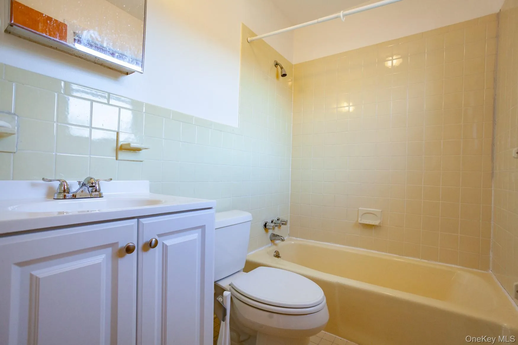 Primary full bathroom featuring tile walls, tub / shower combination, and vanity. Primary full bathroom featuring tile walls, tub / shower combination, and vanity.