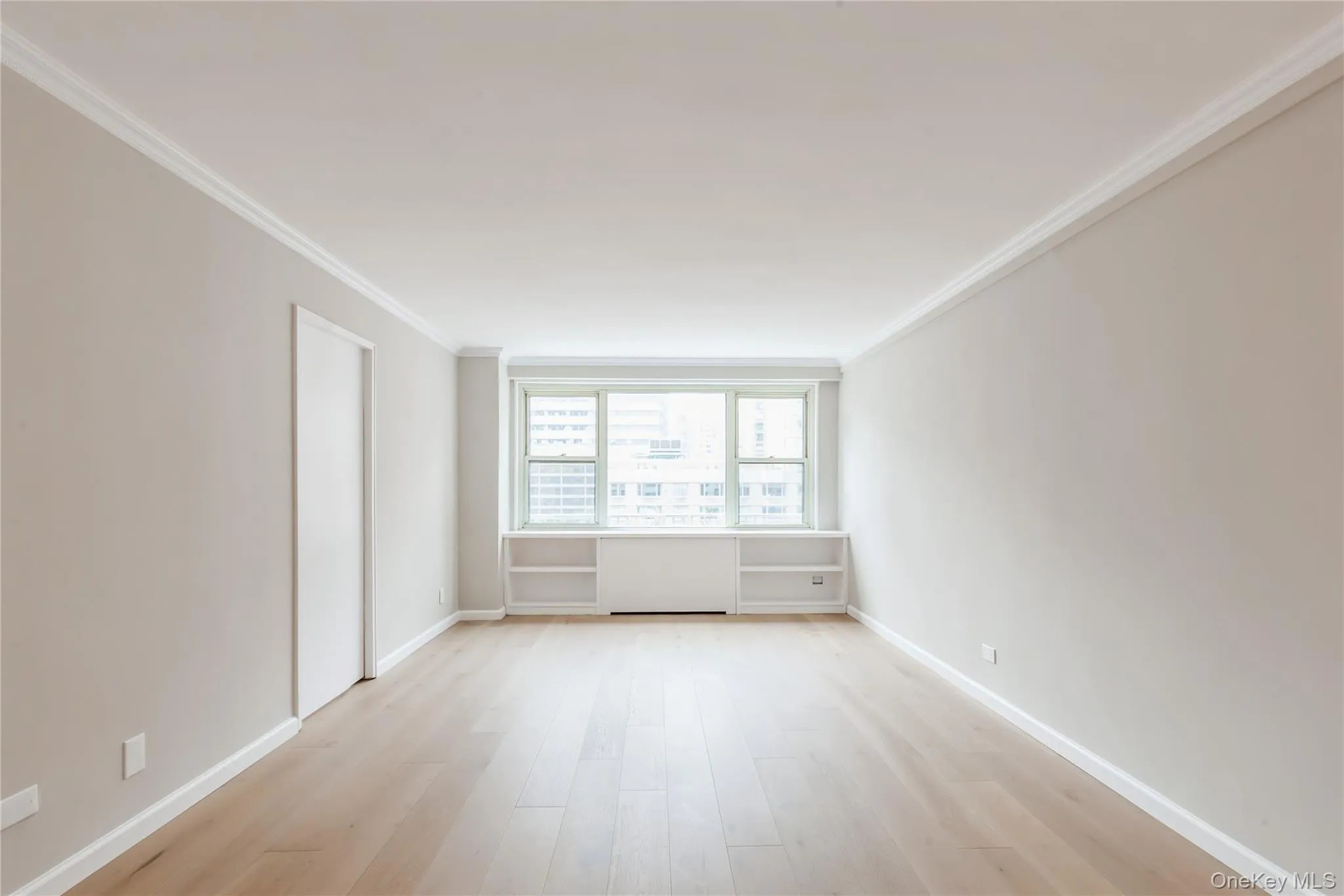 Spare room with ornamental molding and light wood-style flooring Spare room with ornamental molding and light wood-style flooring