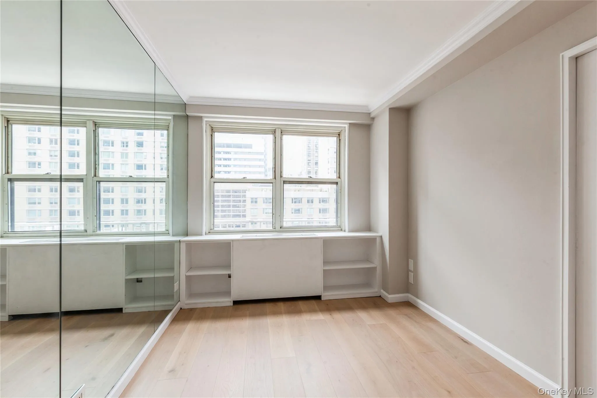 Unfurnished room featuring light wood-style floors and ornamental molding Unfurnished room featuring light wood-style floors and ornamental molding
