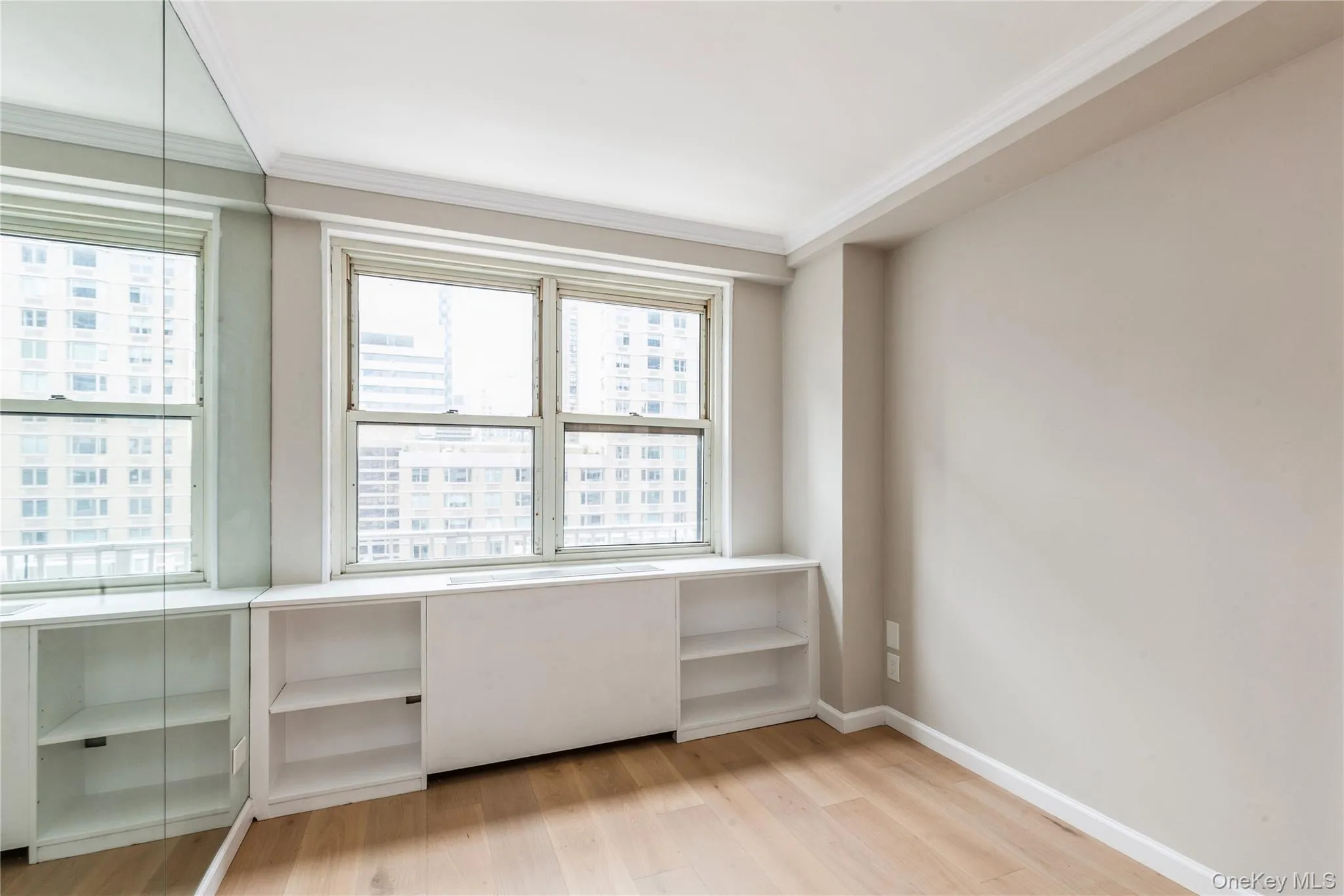 Unfurnished office featuring light wood finished floors and crown molding Unfurnished office featuring light wood finished floors and crown molding