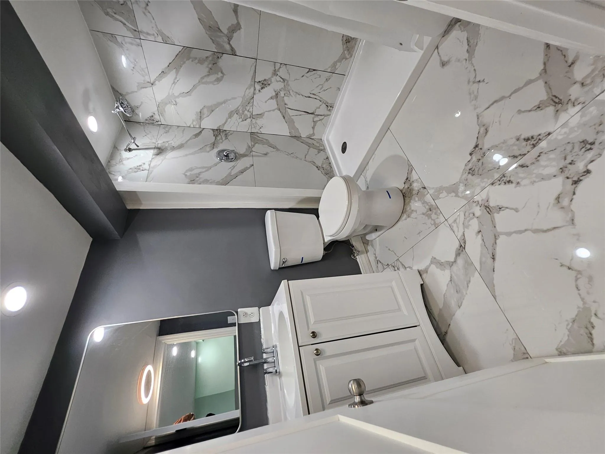 Bathroom featuring vanity, a marble finish shower, marble look tile flooring, and recessed lighting Bathroom featuring vanity, a marble finish shower, marble look tile flooring, and recessed lighting