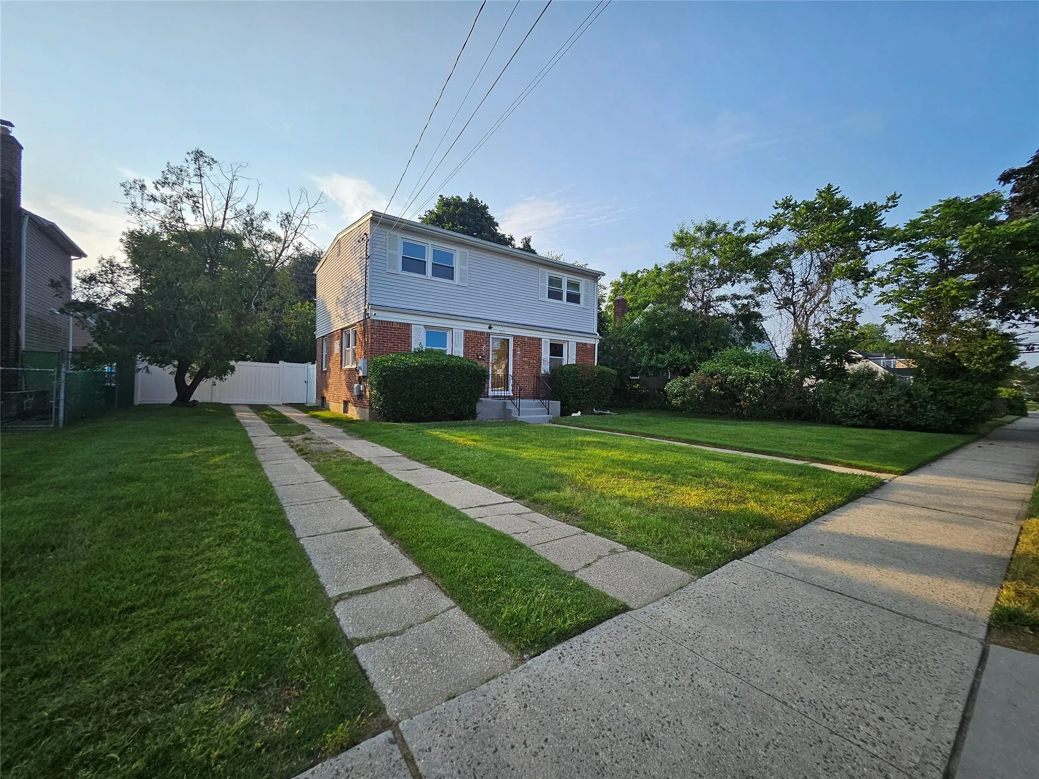 Colonial-style house featuring brick siding and driveway Colonial-style house featuring brick siding and driveway
