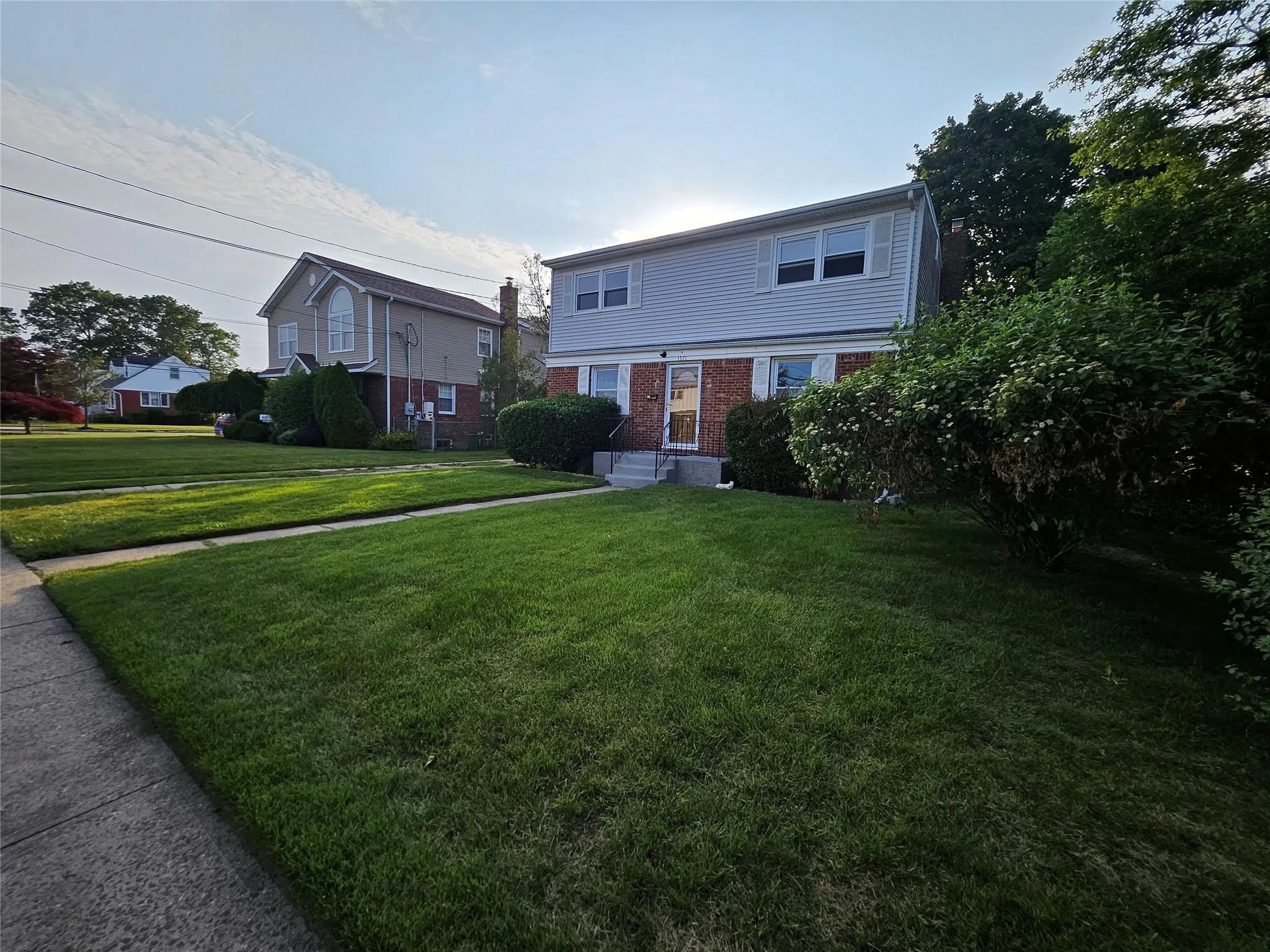 Colonial inspired home with brick siding and a front lawn Colonial inspired home with brick siding and a front lawn