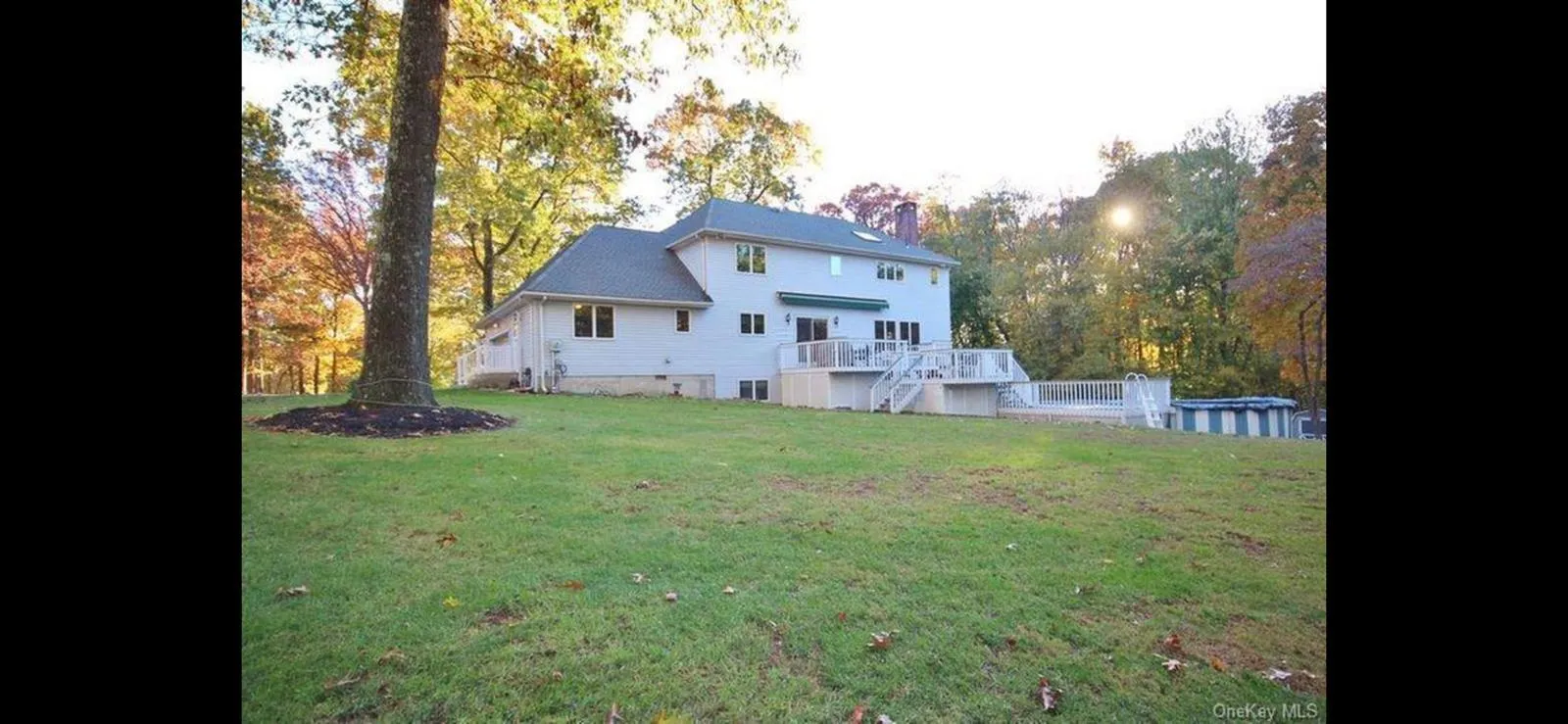 Rear view of house with stairs, a yard, an outdoor pool, a chimney, and a deck Rear view of house with stairs, a yard, an outdoor pool, a chimney, and a deck
