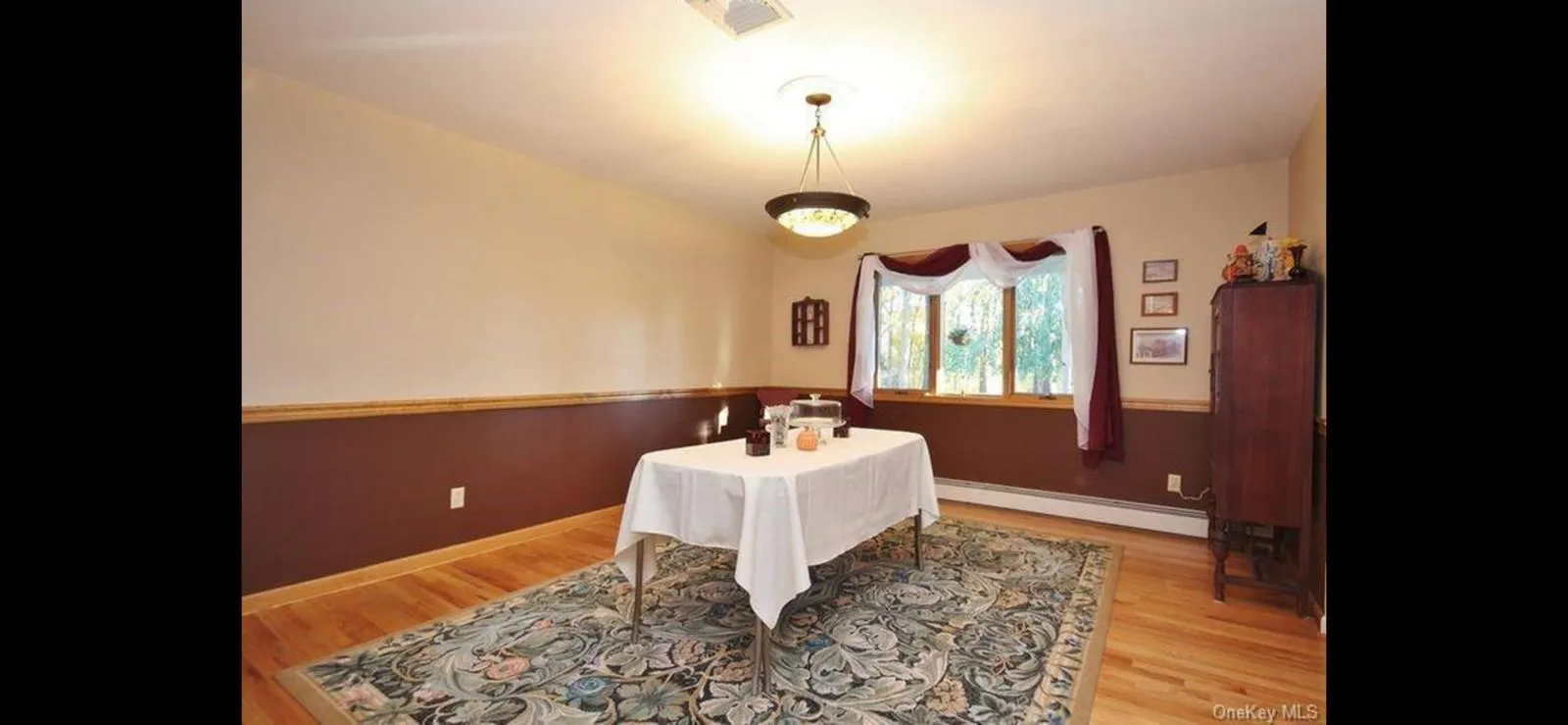 Dining space with wood finished floors and a baseboard heating unit Dining space with wood finished floors and a baseboard heating unit