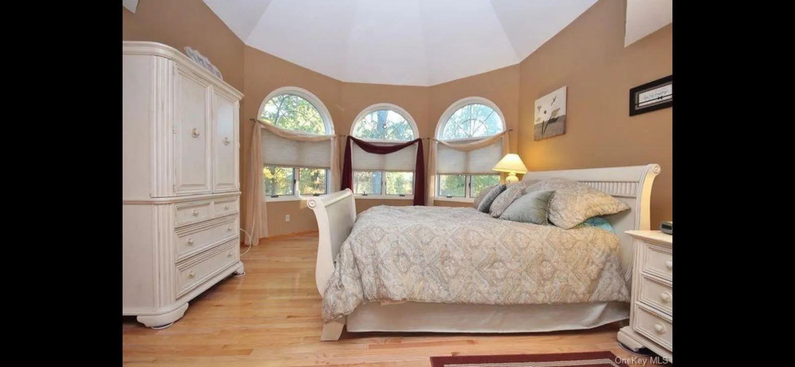 Bedroom with lofted ceiling and light wood finished floors Bedroom with lofted ceiling and light wood finished floors