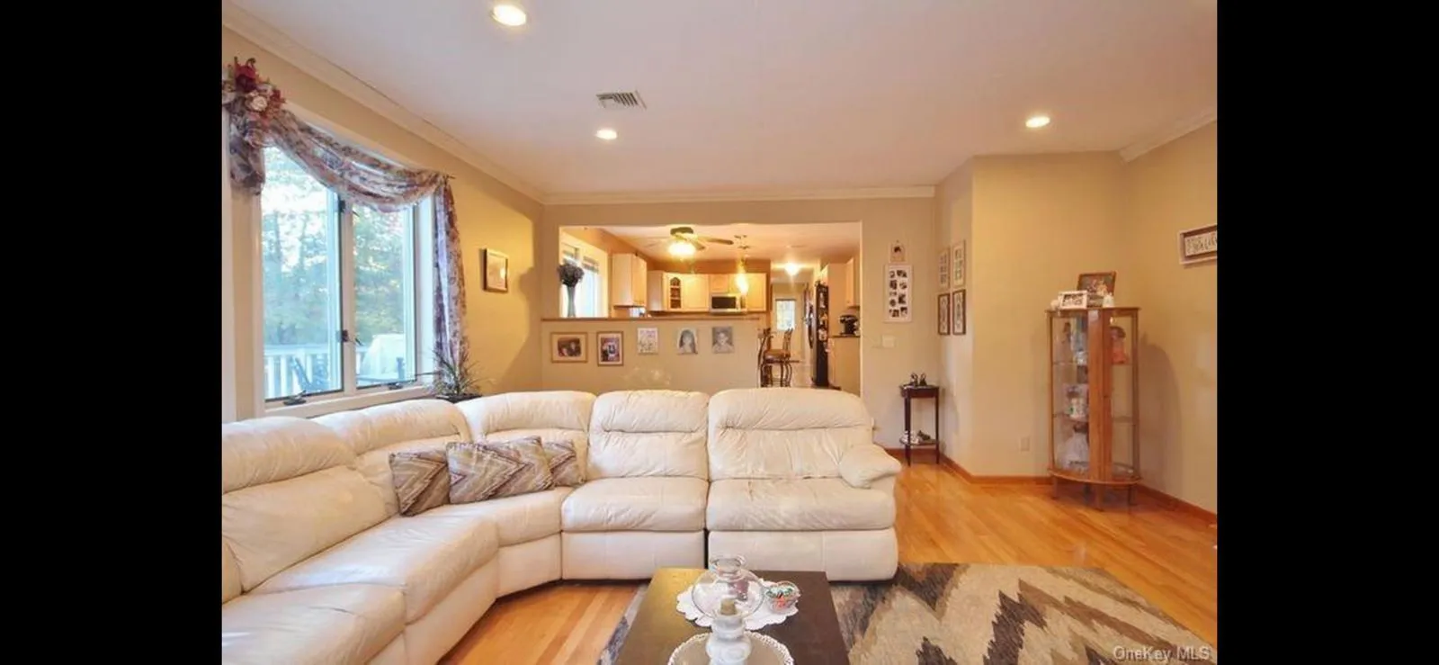 Living area with ornamental molding, light wood-style floors, and recessed lighting Living area with ornamental molding, light wood-style floors, and recessed lighting
