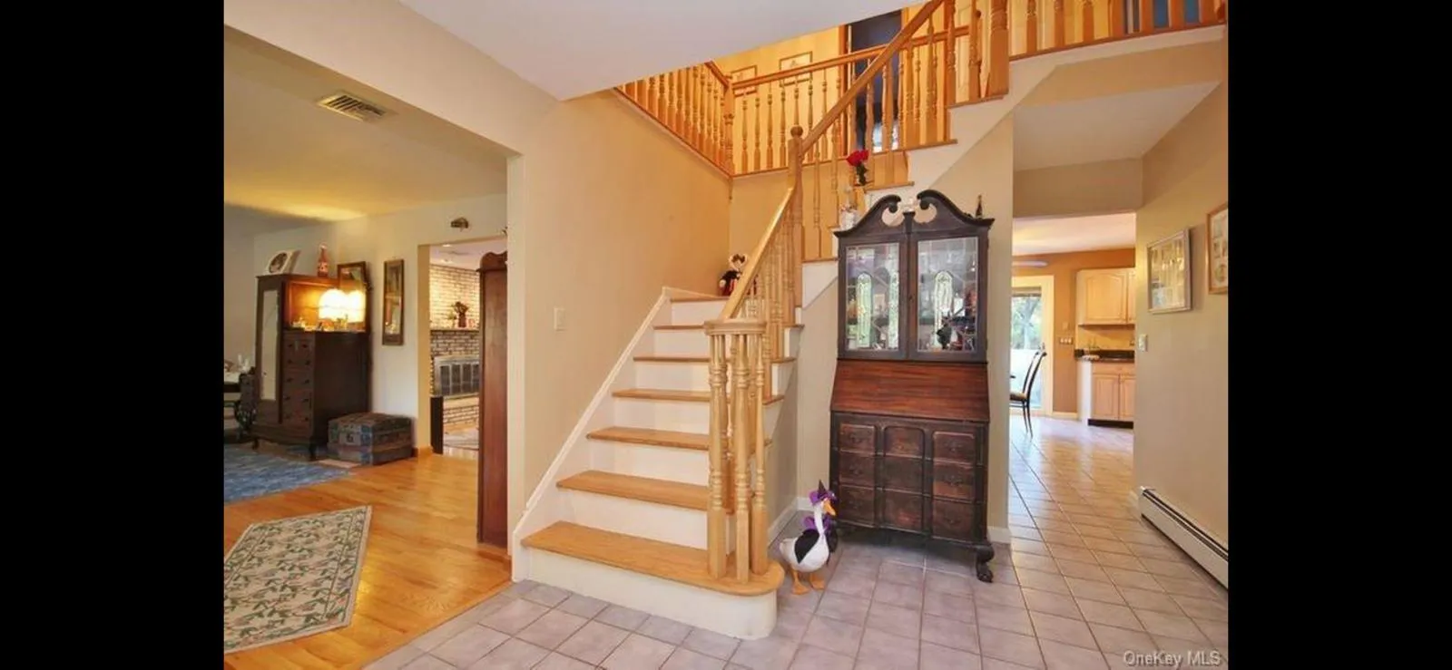 Stairway with a baseboard radiator, tile patterned floors, and a high ceiling Stairway with a baseboard radiator, tile patterned floors, and a high ceiling
