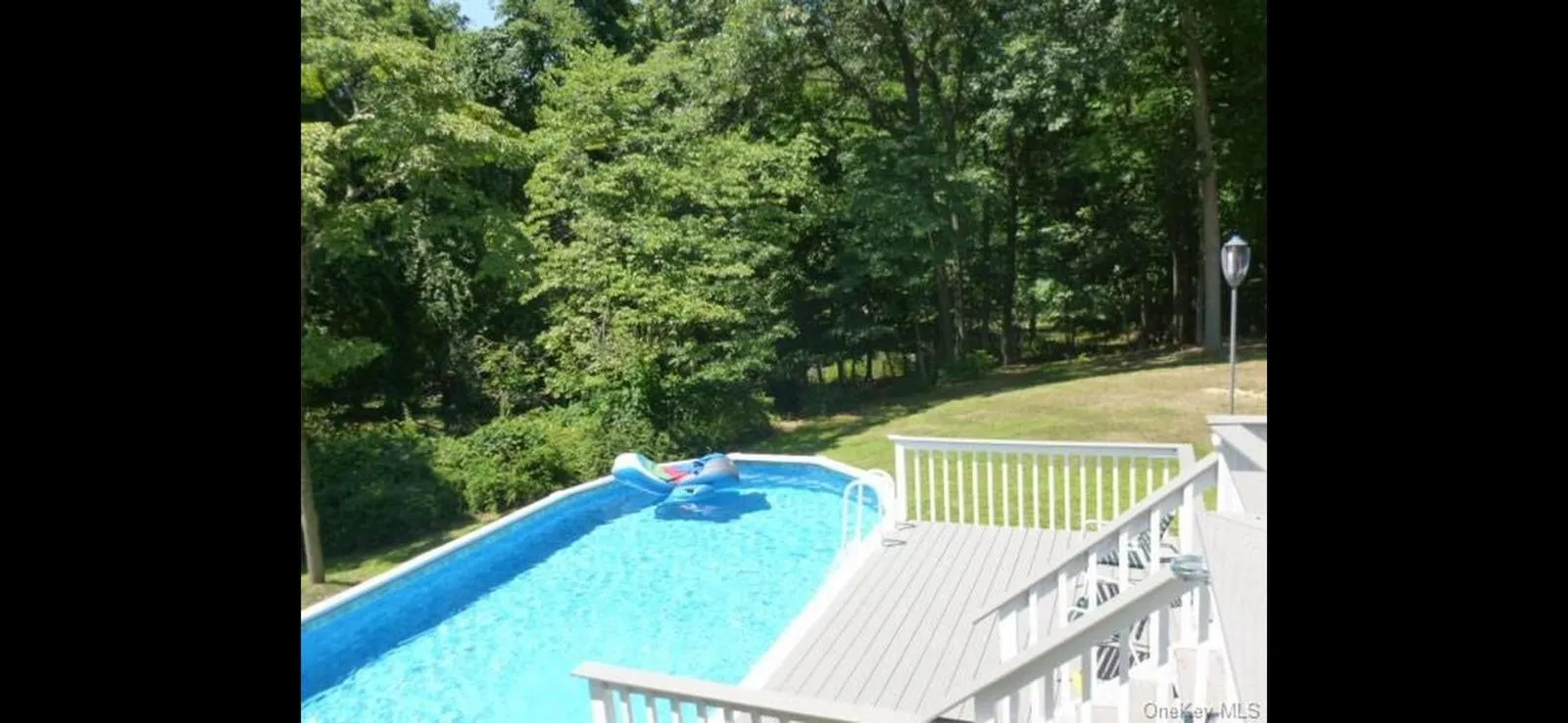 View of pool with a wooden deck and a yard View of pool with a wooden deck and a yard