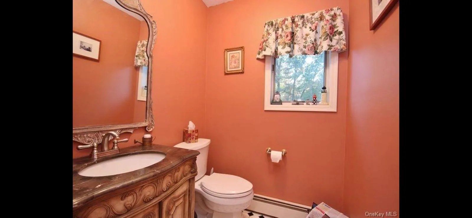 Half bath featuring baseboard heating and vanity Half bath featuring baseboard heating and vanity