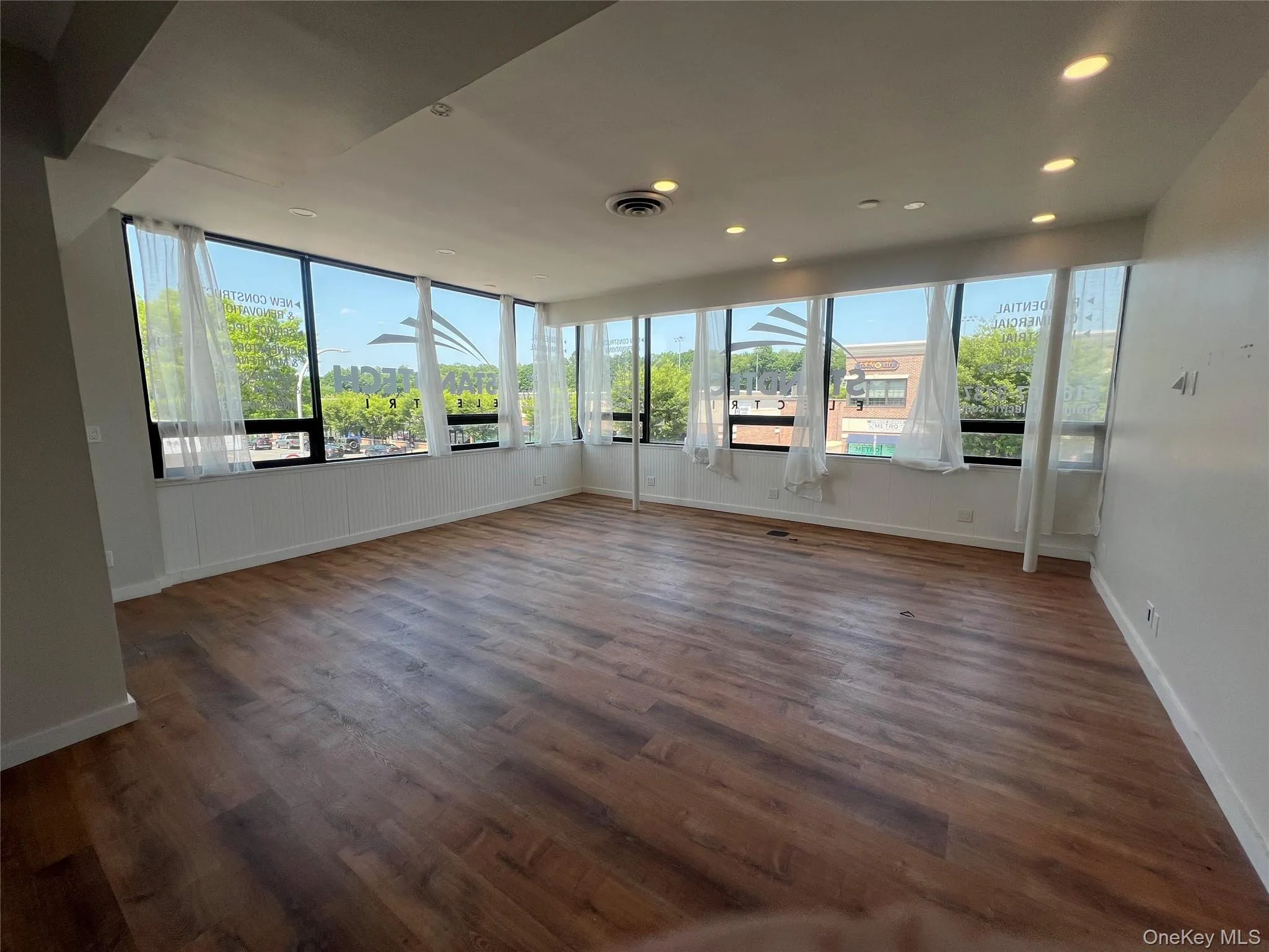 Unfurnished sunroom with wood finished floors and recessed lighting Unfurnished sunroom with wood finished floors and recessed lighting