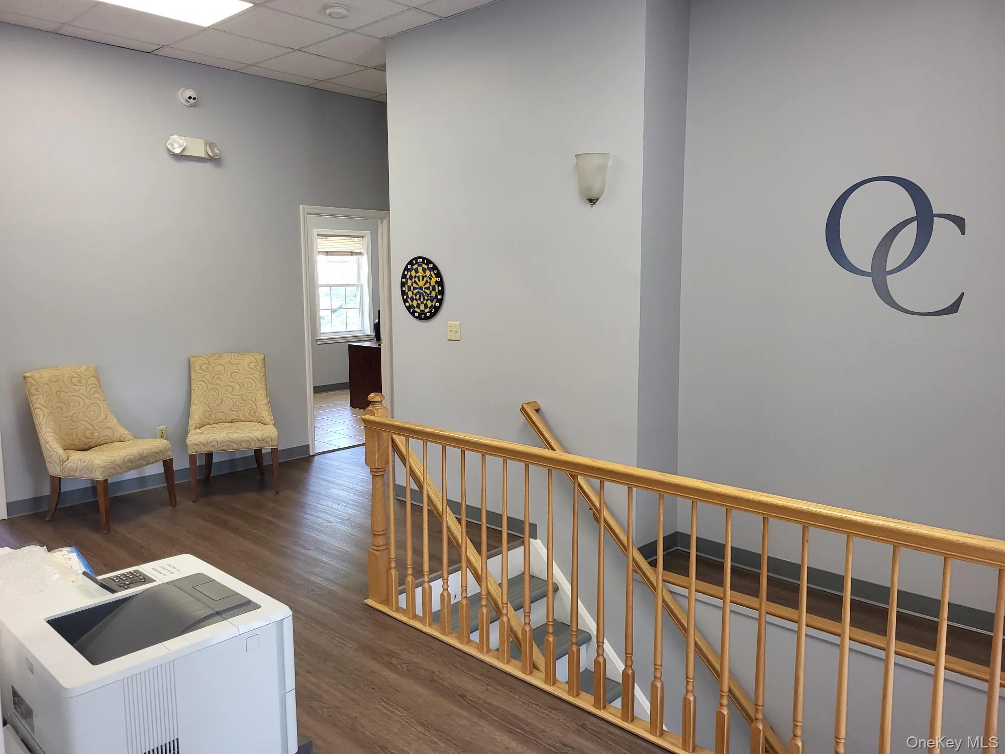 Corridor with an upstairs landing, a paneled ceiling, and wood finished floors Corridor with an upstairs landing, a paneled ceiling, and wood finished floors