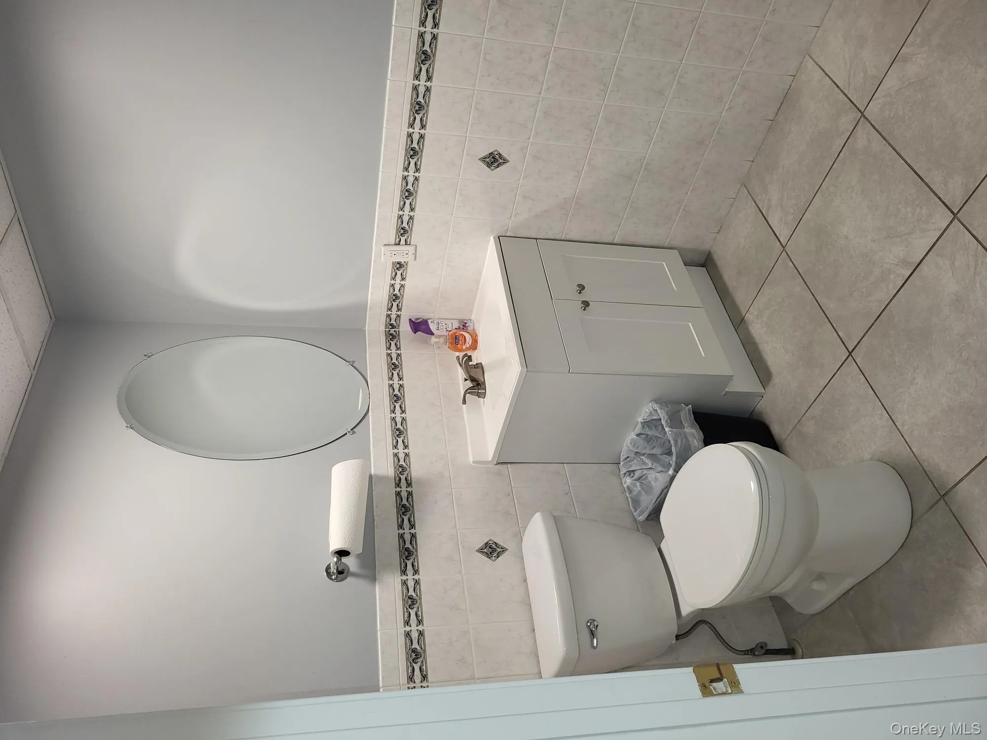 Half bathroom featuring vanity, a wainscoted wall, tile walls, tile patterned flooring, and a paneled ceiling Half bathroom featuring vanity, a wainscoted wall, tile walls, tile patterned flooring, and a paneled ceiling