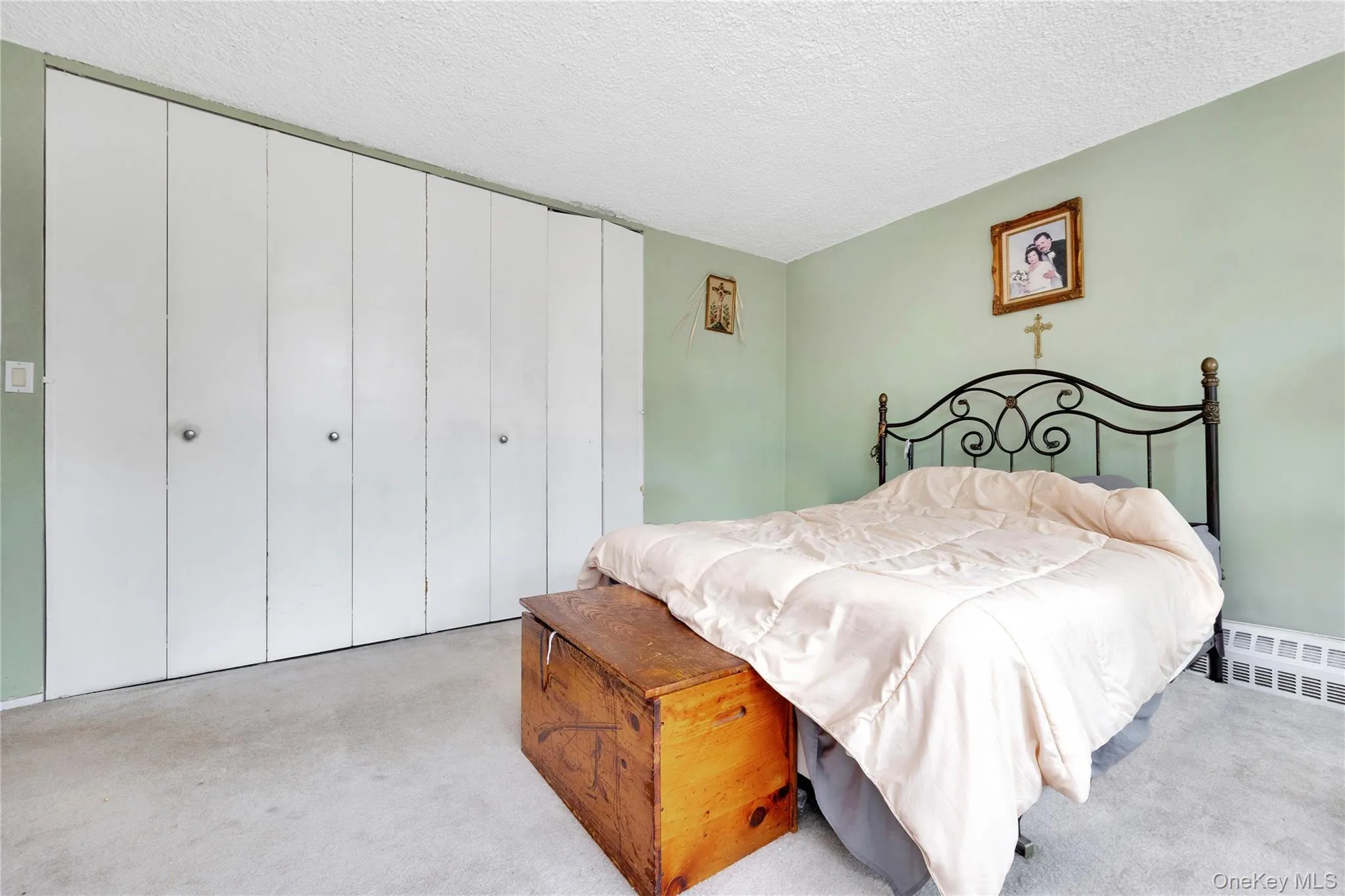 Bedroom featuring carpet flooring, a closet, and a textured ceiling Bedroom featuring carpet flooring, a closet, and a textured ceiling