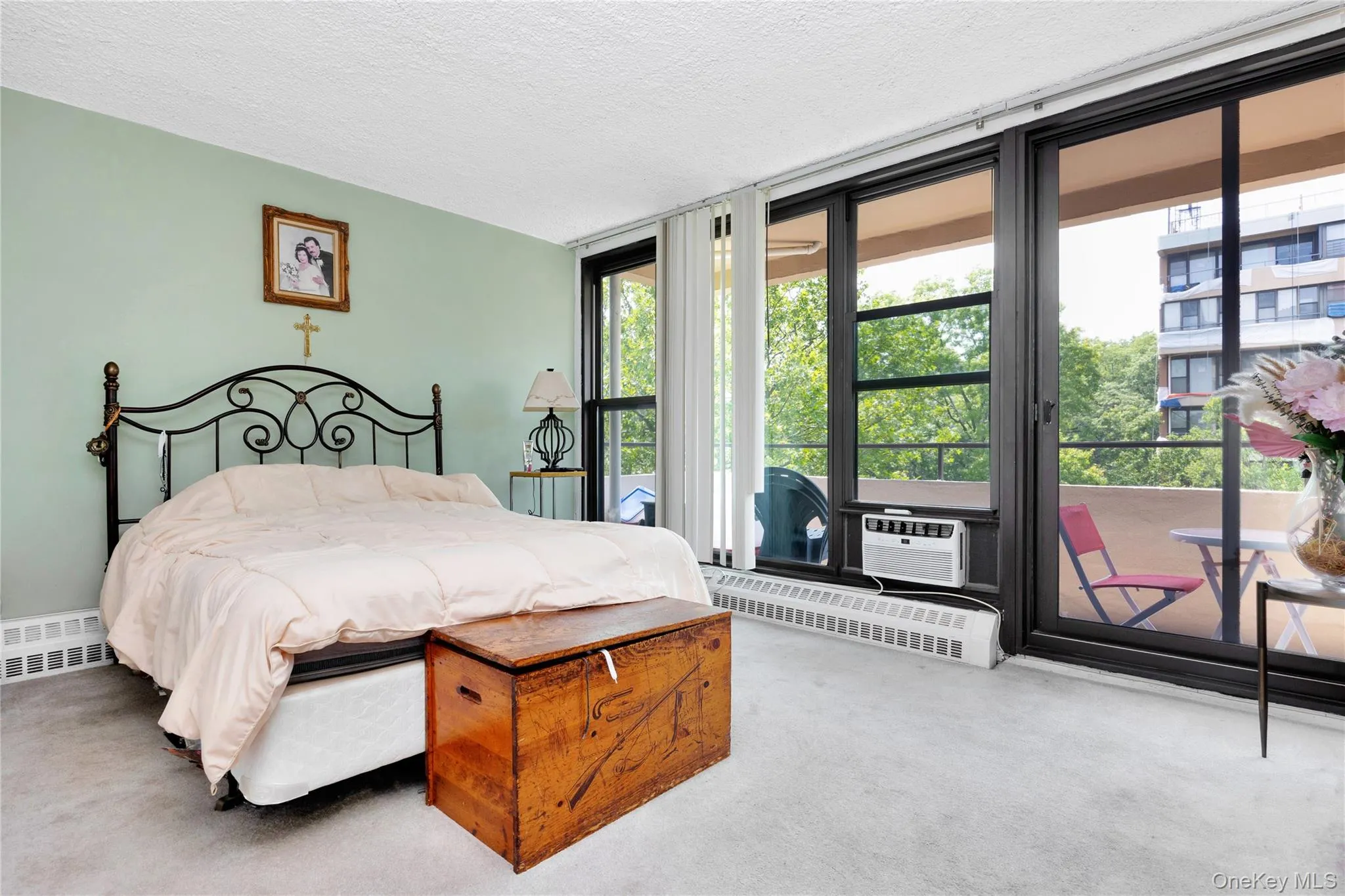 Bedroom with multiple windows, access to outside, carpet, a wall of windows, and a textured ceiling Bedroom with multiple windows, access to outside, carpet, a wall of windows, and a textured ceiling
