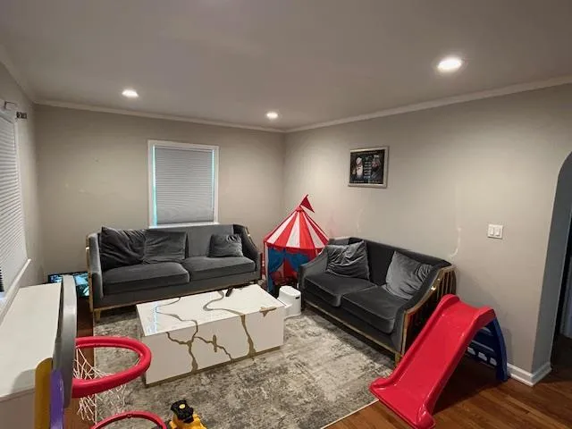 Living room featuring wood finished floors, recessed lighting, and ornamental molding Living room featuring wood finished floors, recessed lighting, and ornamental molding