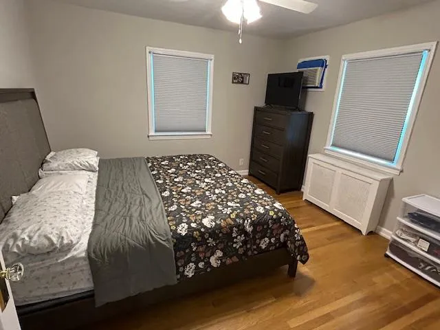 Bedroom with wood finished floors and a ceiling fan Bedroom with wood finished floors and a ceiling fan