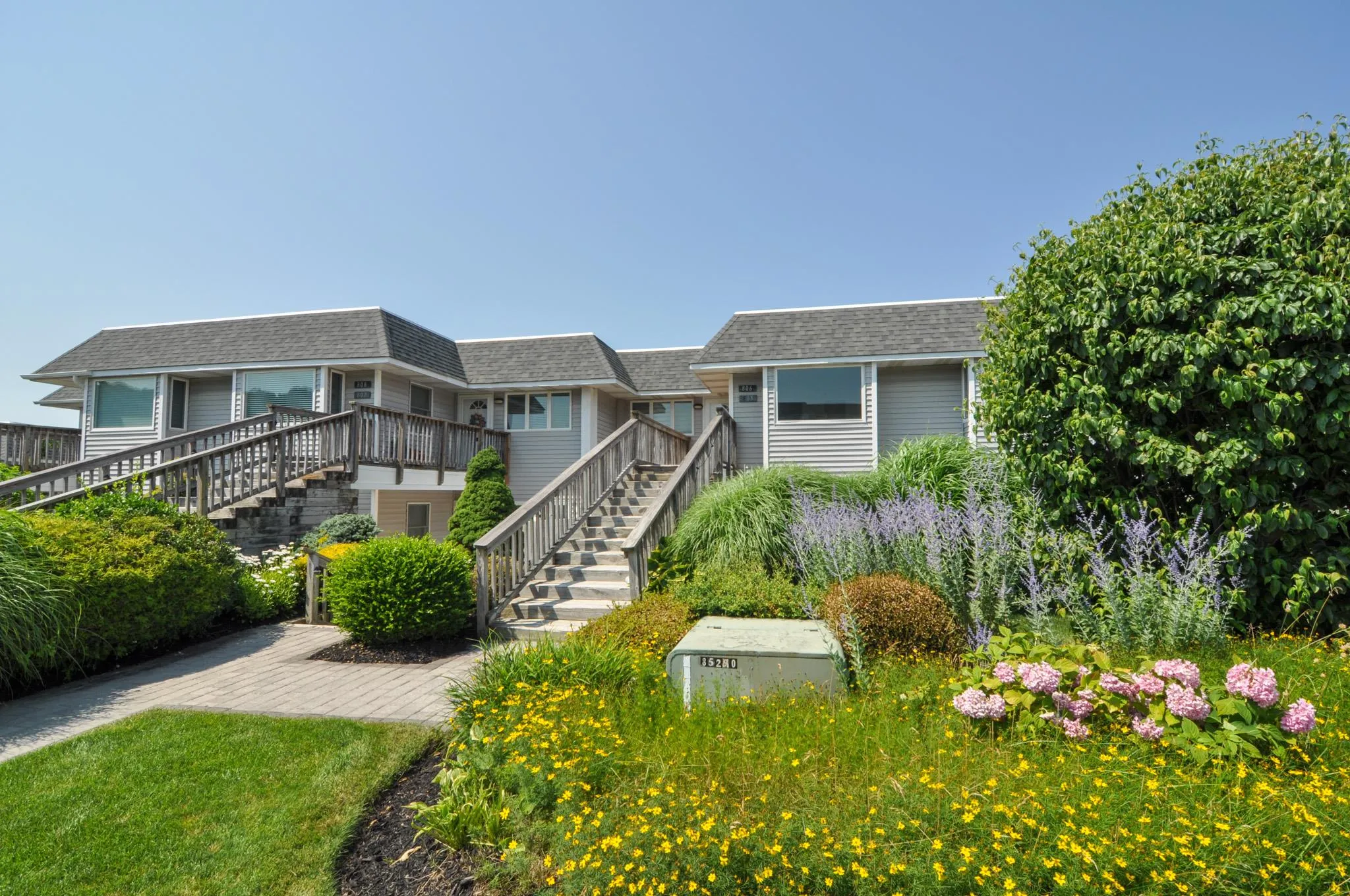 View of front of property featuring stairway and a shingled roof View of front of property featuring stairway and a shingled roof