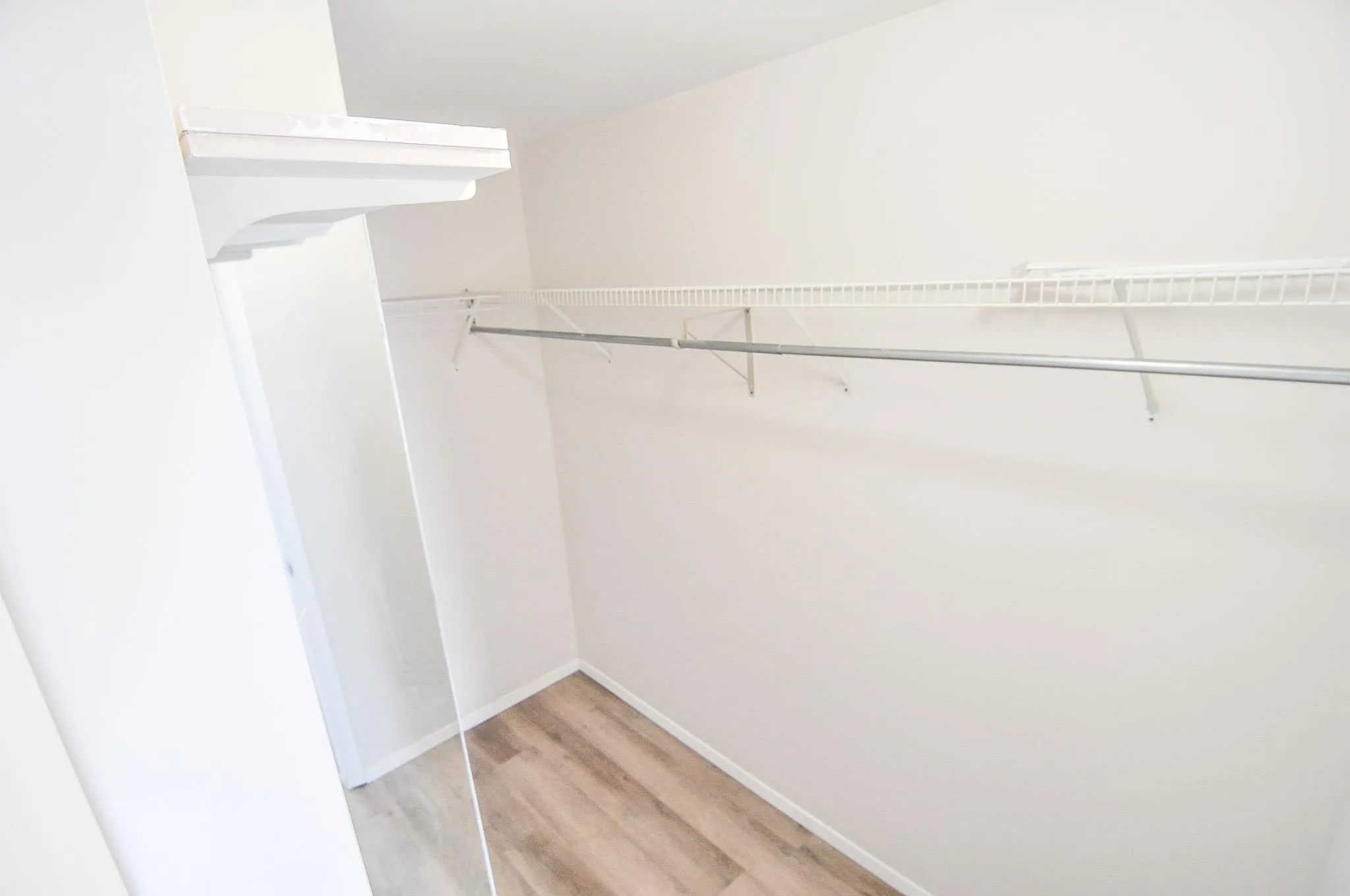 Spacious walk-in closet featuring light wood-type flooring Spacious walk-in closet featuring light wood-type flooring