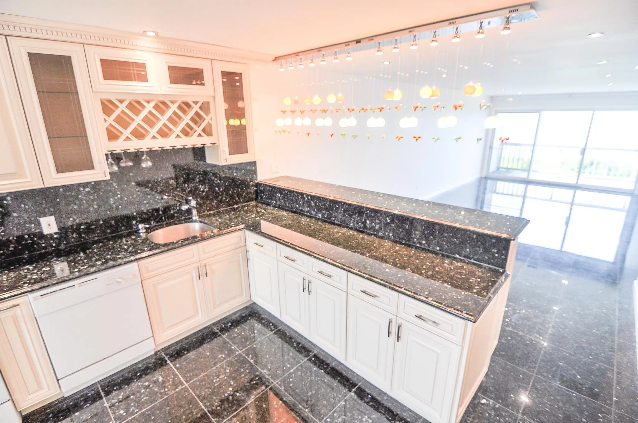 Kitchen featuring dishwasher, granite tiled floors, a peninsula, recessed lighting, and glass insert cabinets Kitchen featuring dishwasher, granite tiled floors, a peninsula, recessed lighting, and glass insert cabinets