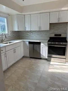 Kitchen featuring appliances with stainless steel finishes, light countertops, and tasteful backsplash Kitchen featuring appliances with stainless steel finishes, light countertops, and tasteful backsplash