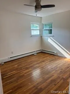 Empty room with wood finished floors and a ceiling fan Empty room with wood finished floors and a ceiling fan