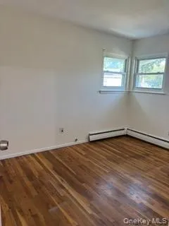Empty room featuring wood finished floors and baseboards Empty room featuring wood finished floors and baseboards