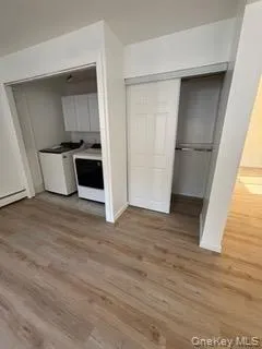 Kitchen featuring washing machine and dryer and light wood finished floors Kitchen featuring washing machine and dryer and light wood finished floors