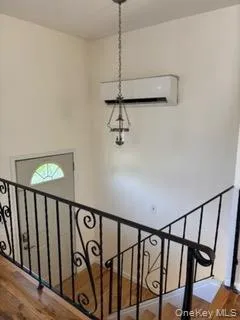 Stairway with wood finished floors and a wall mounted AC Stairway with wood finished floors and a wall mounted AC