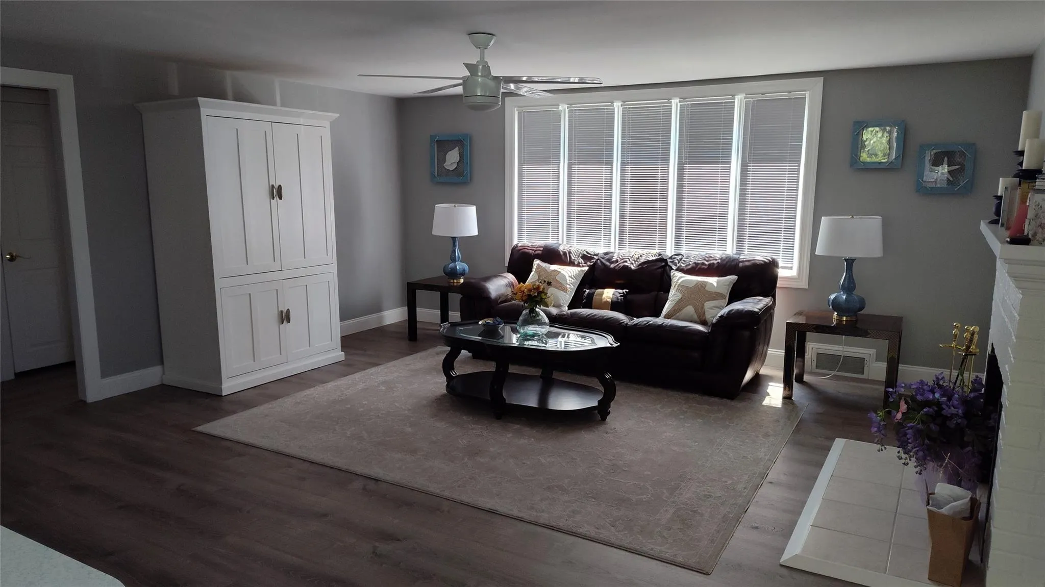 Living area featuring ceiling fan and dark wood-style floors Living area featuring ceiling fan and dark wood-style floors