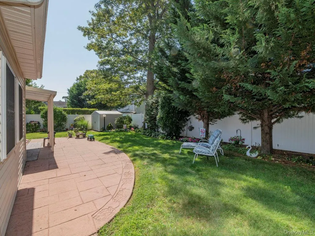 Fenced backyard with a patio area and a shed Fenced backyard with a patio area and a shed