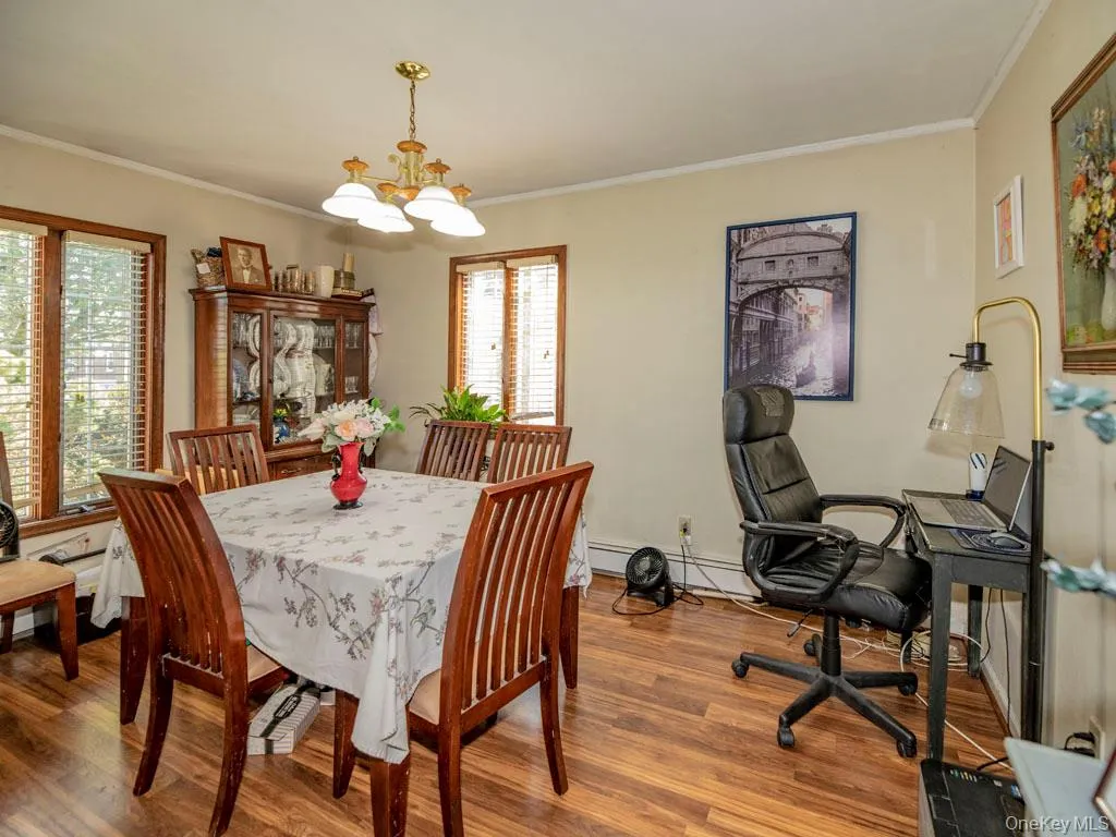 Dining space with crown molding, a chandelier, and wood finished floors Dining space with crown molding, a chandelier, and wood finished floors