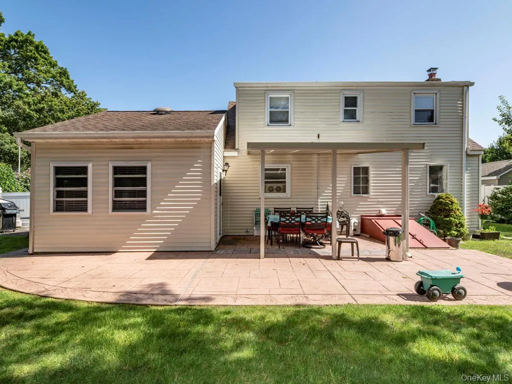 Rear view of property featuring a patio, a yard, and a chimney Rear view of property featuring a patio, a yard, and a chimney