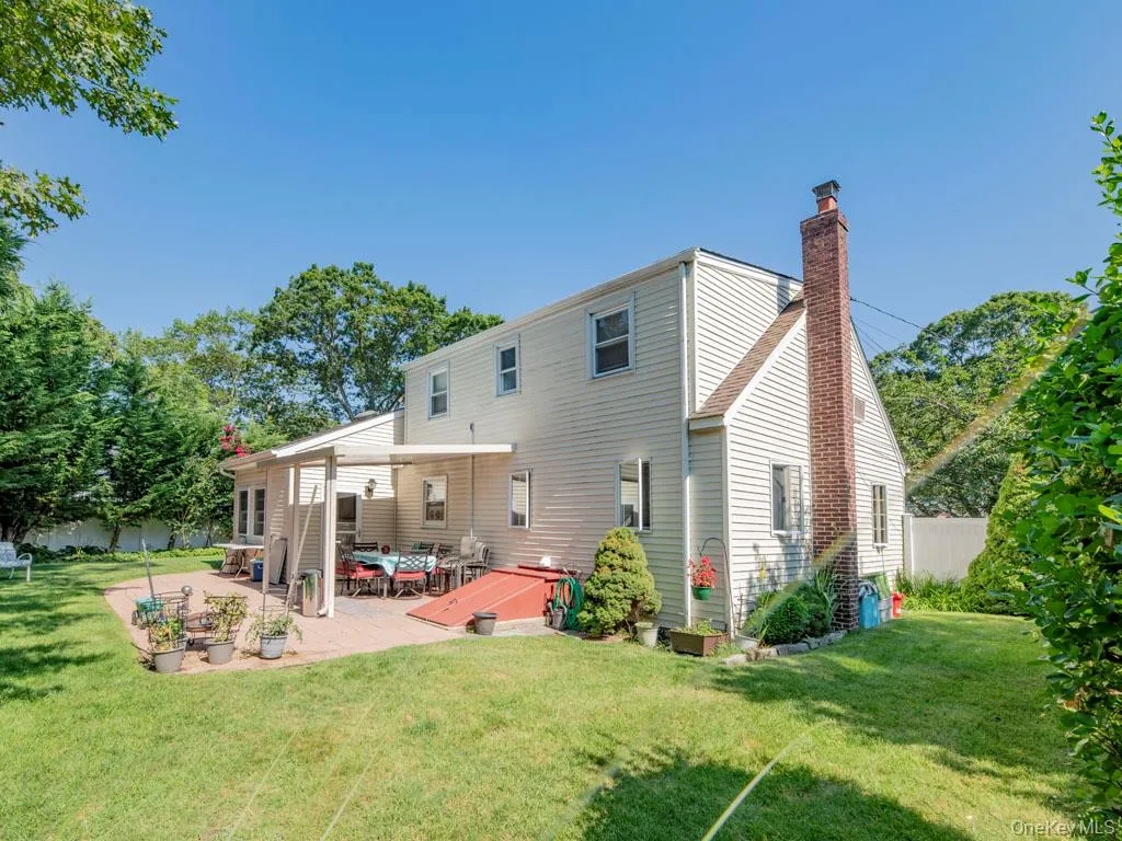 Rear view of house featuring a chimney and a patio Rear view of house featuring a chimney and a patio