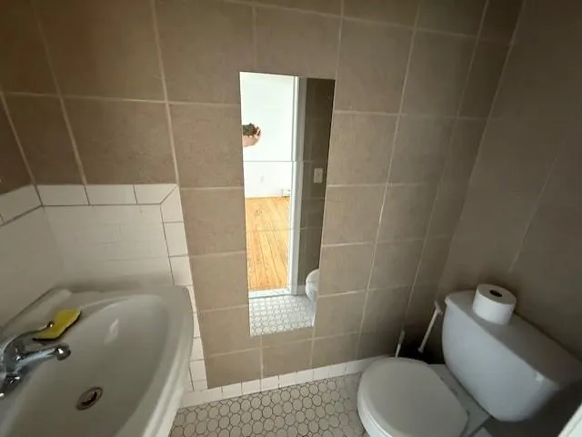 Half bathroom featuring tile walls and toilet Half bathroom featuring tile walls and toilet